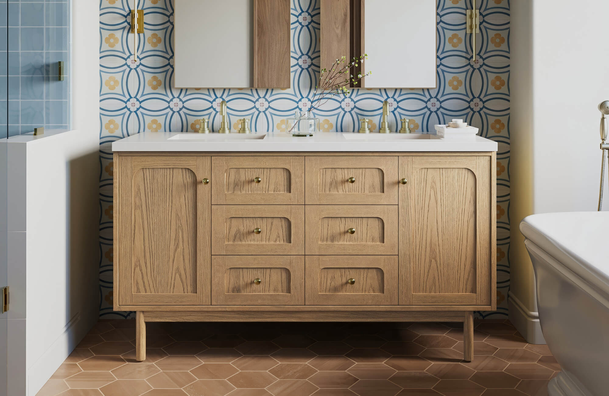 Wood double-sink bathroom vanity with brass hardware, set against a patterned tile backsplash and hexagon terracotta flooring.