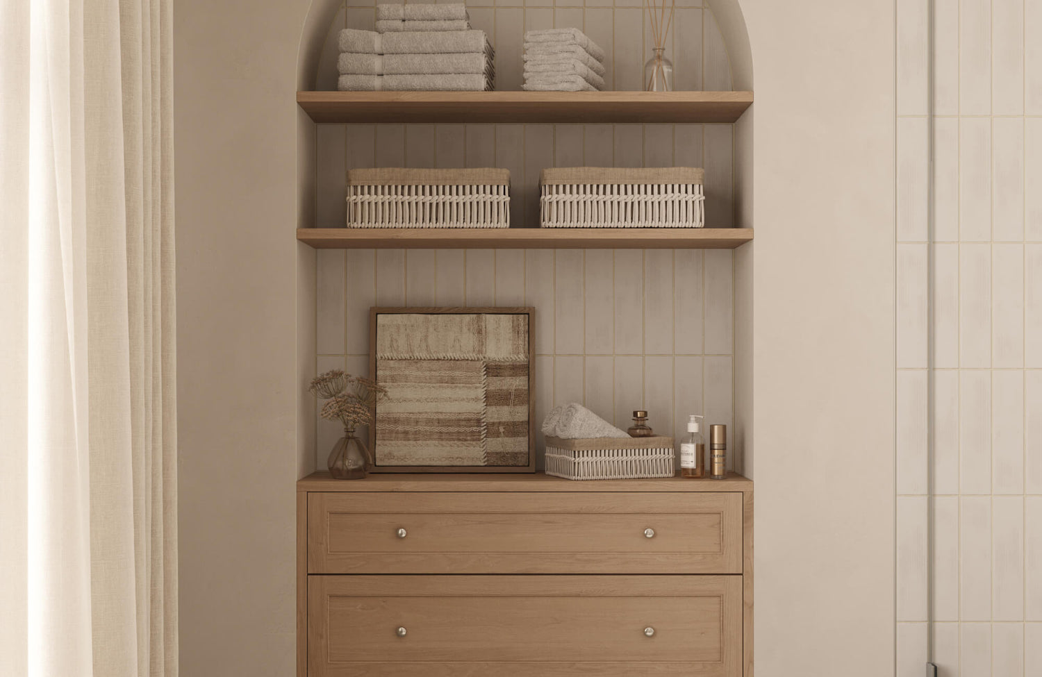 Neutral bathroom with vertical cream tile walls, warm wood vanity, woven baskets, folded towels, and framed wall art.