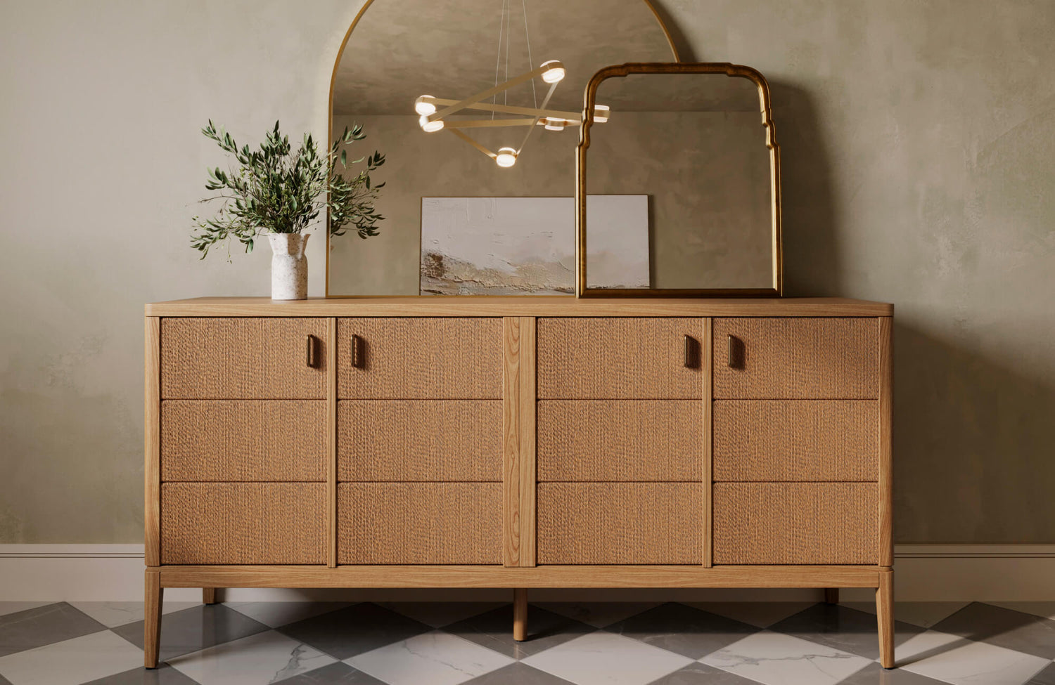 Mid-century oak sideboard with textured drawer fronts and leather pulls, styled with layered mirrors and ceramic vase decor.