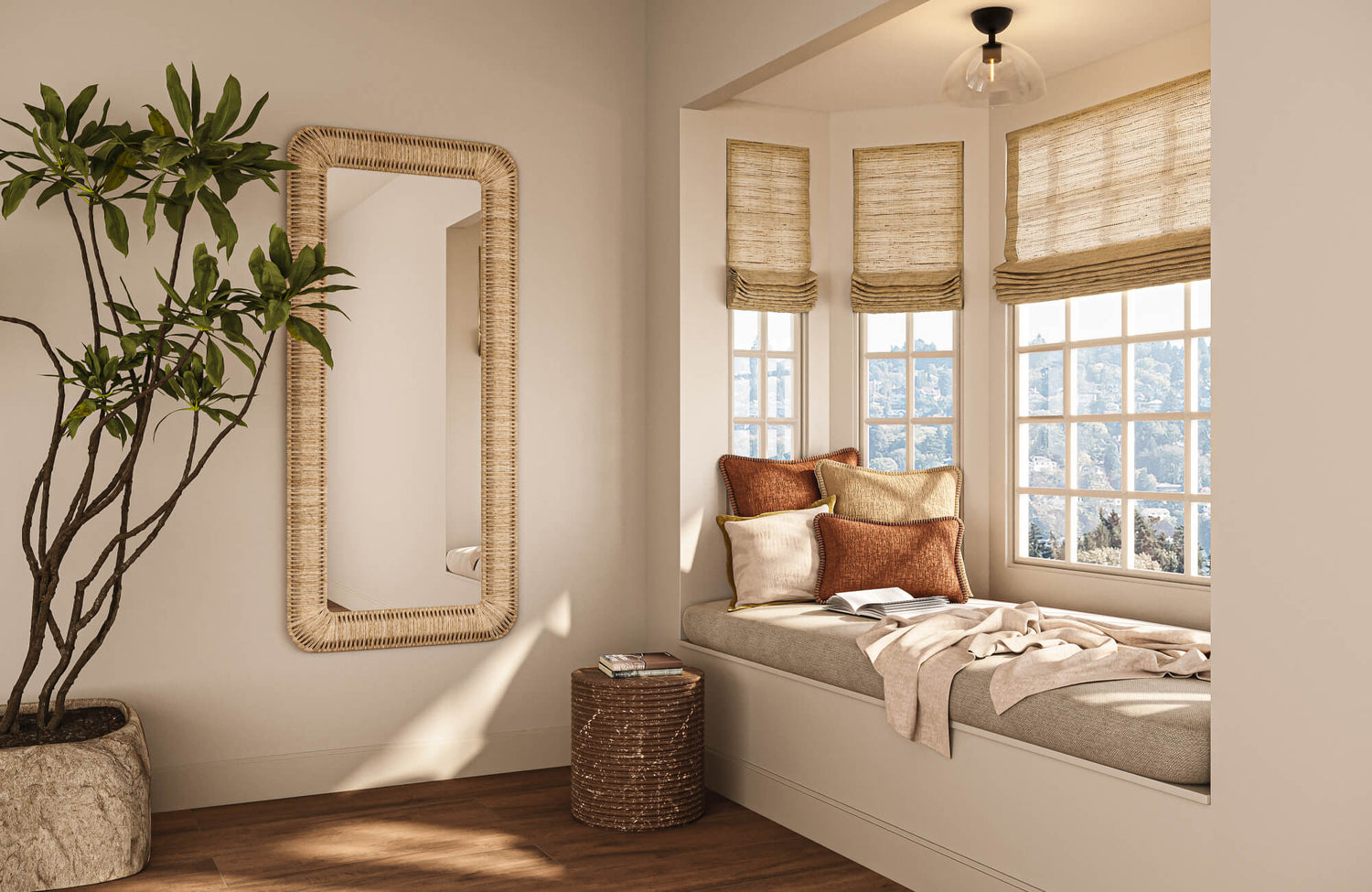 Sunlit window nook styled with layered rust and cream throw pillows on a cushioned bench, framed by woven roman shades, a rattan mirror, and warm wood flooring.