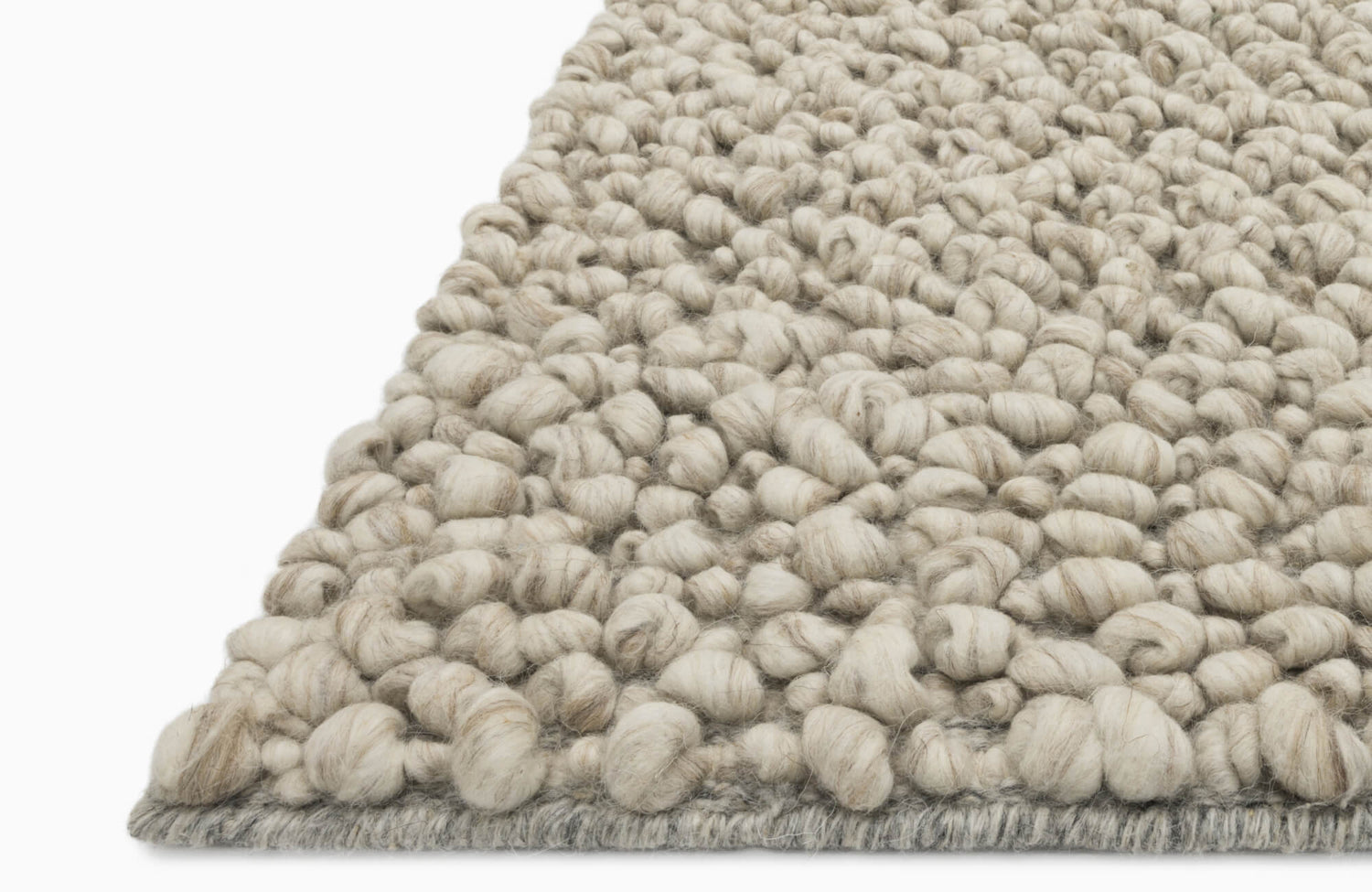 Close-up of a chunky handwoven wool rug in natural ivory tones, showcasing thick, twisted yarn loops for rich texture.