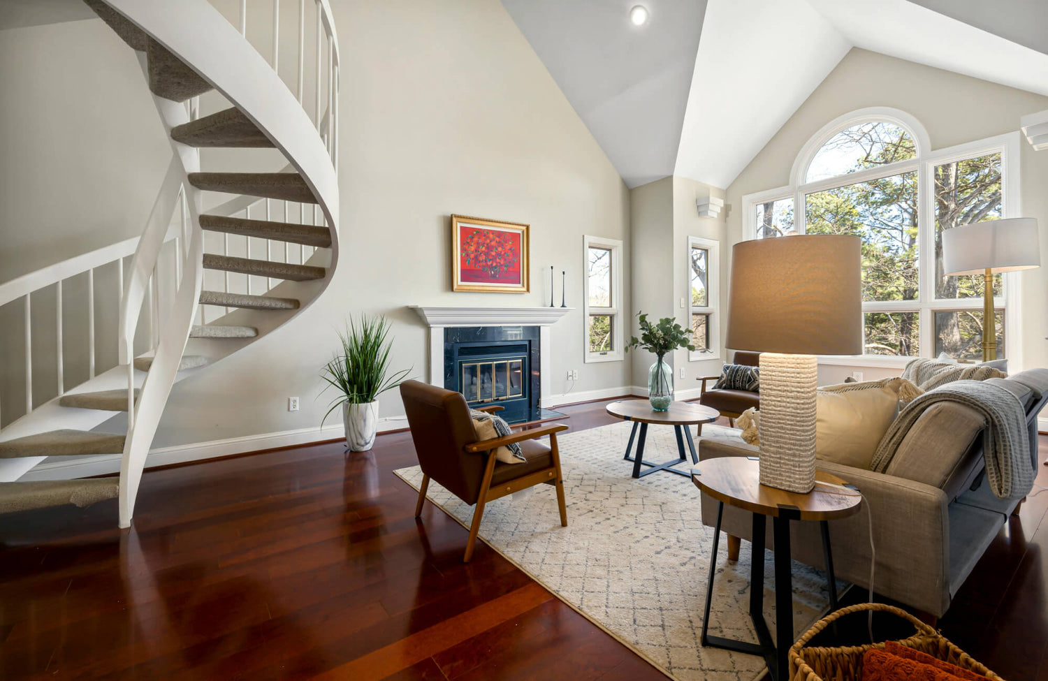 Open living room with a 9x12 rug anchoring sofa and chairs, creating a clear seating zone within a spacious, airy layout.