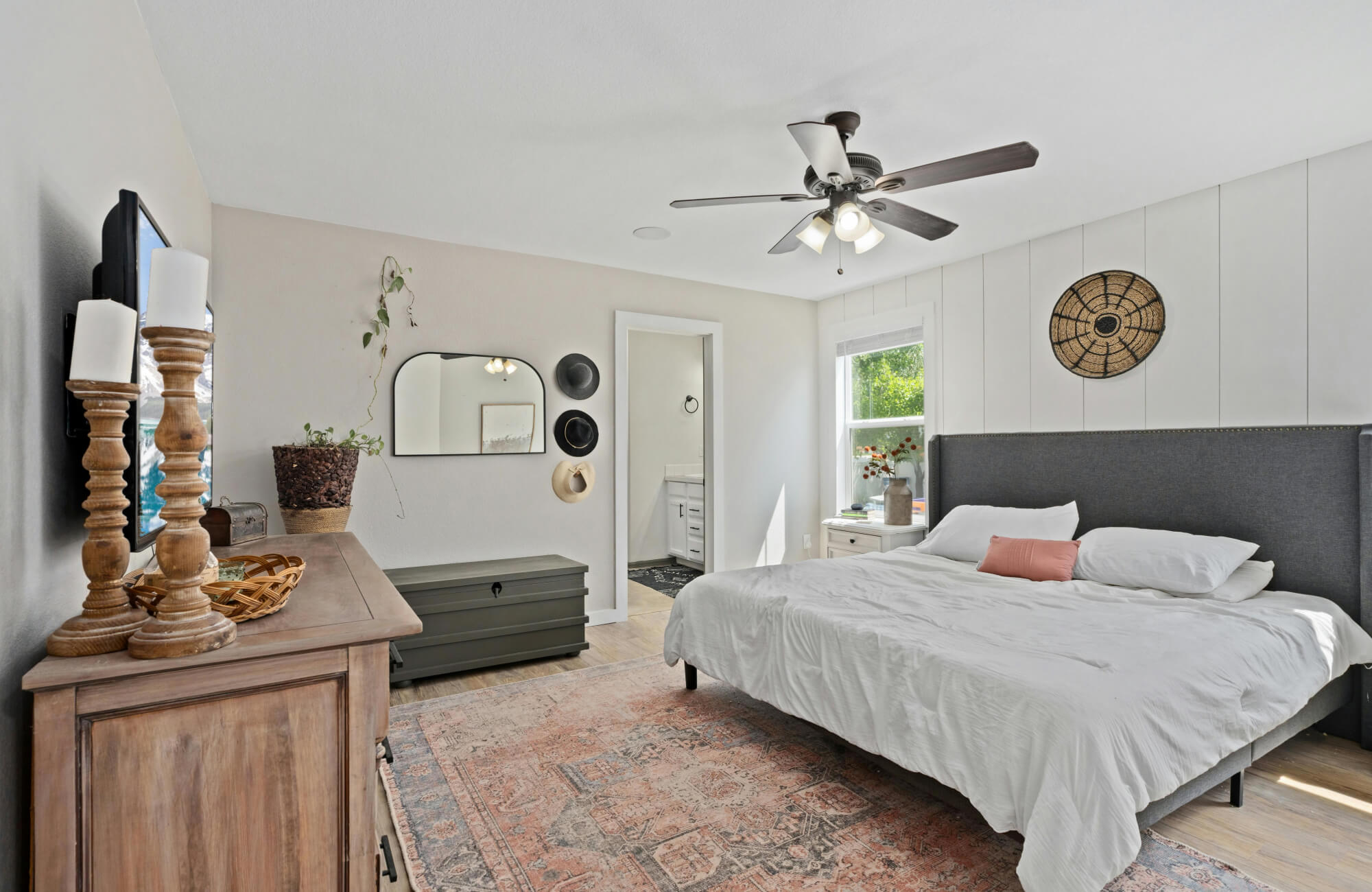 King-size bed anchored by a large area rug extending beyond the sides and foot, creating balanced coverage and comfortable walking space.