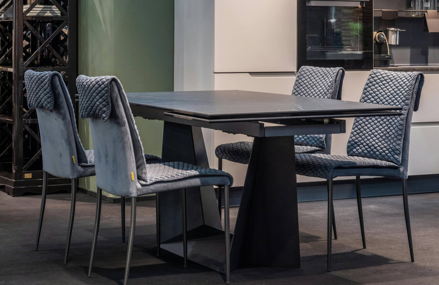 Modern dining setting showcasing a plush, quilted dining chair upholstered in soft gray fabric, paired with a sleek black dining table to create a refined, contemporary atmosphere.