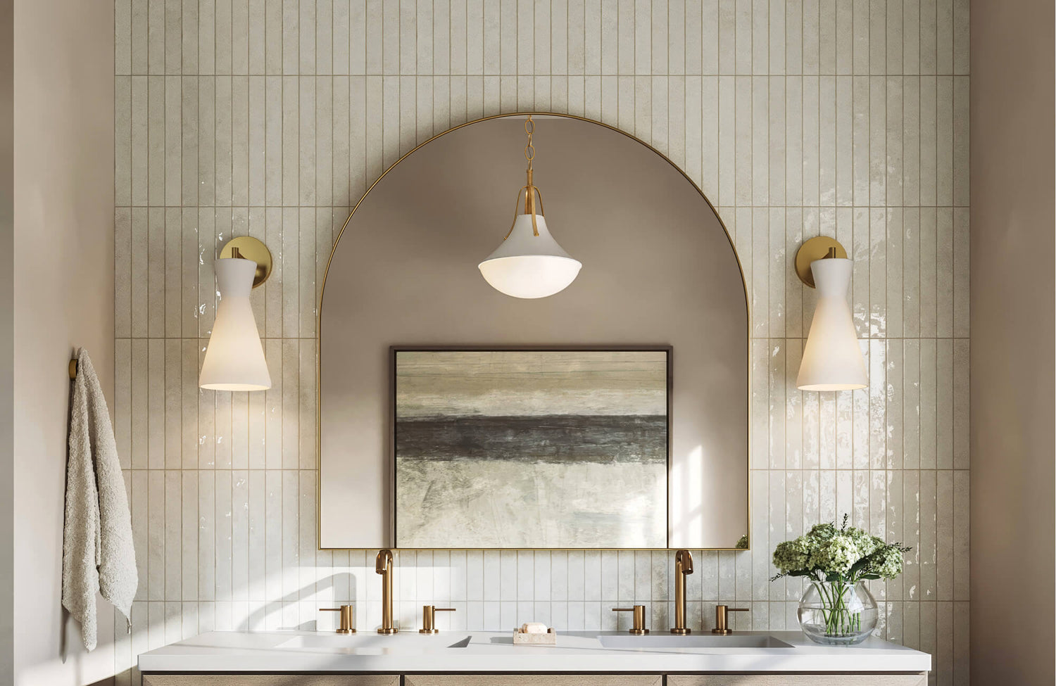 Elegant bathroom with vertical cream subway tile walls, arched brass mirror, warm gold fixtures, and soft neutral wall art.