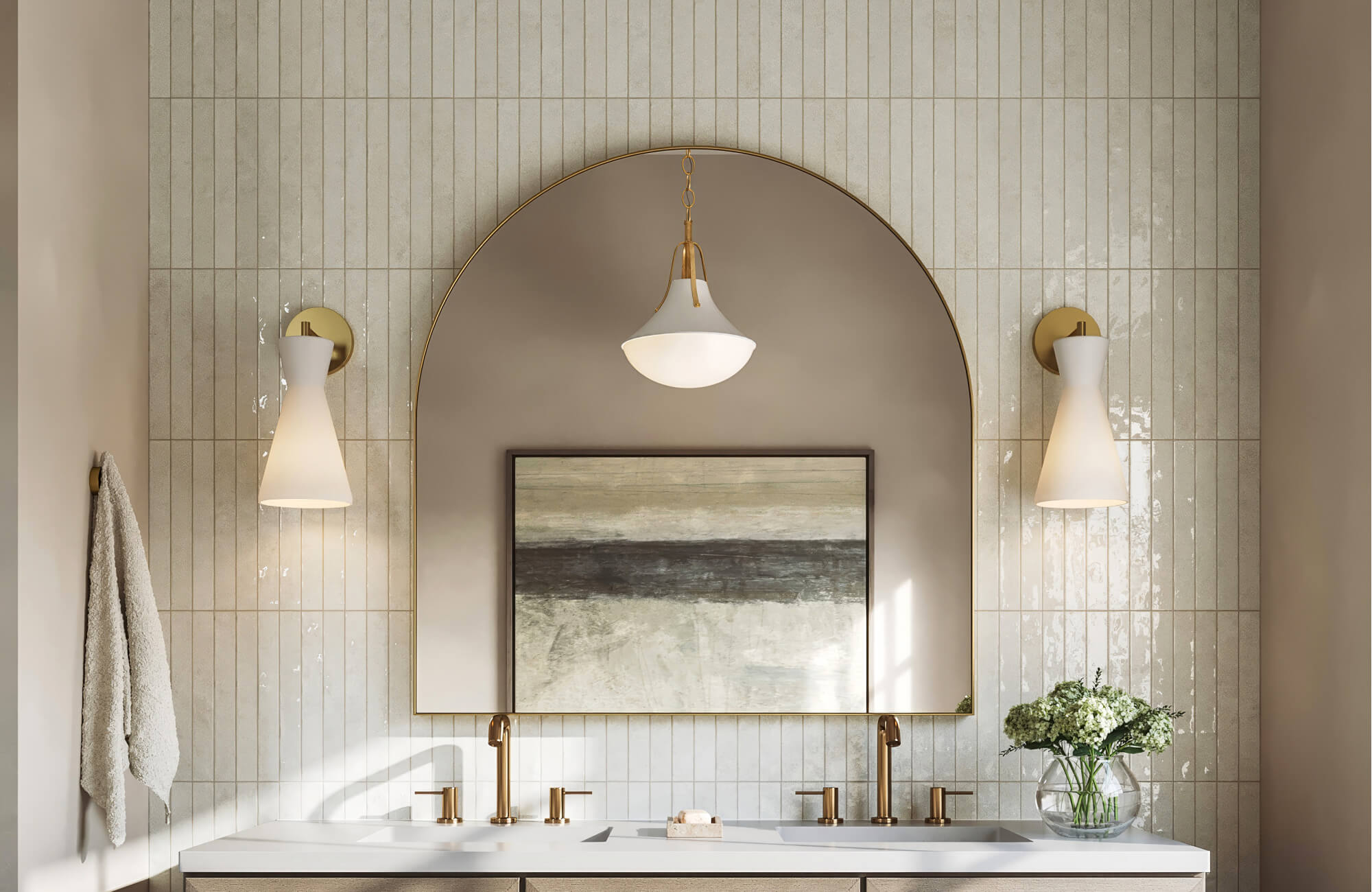 Elegant bathroom with vertical cream subway tile walls, arched brass mirror, warm gold fixtures, and soft neutral wall art.