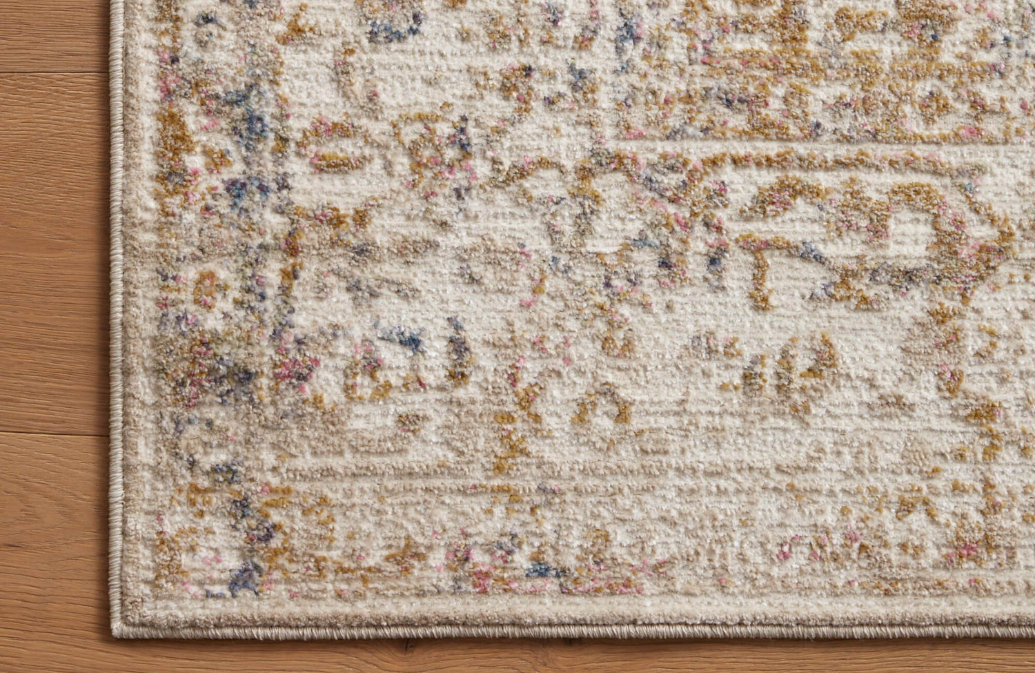 Distressed polypropylene and polyester rug in cream with hints of gold, pink, and blue, blending vintage charm with modern durability.