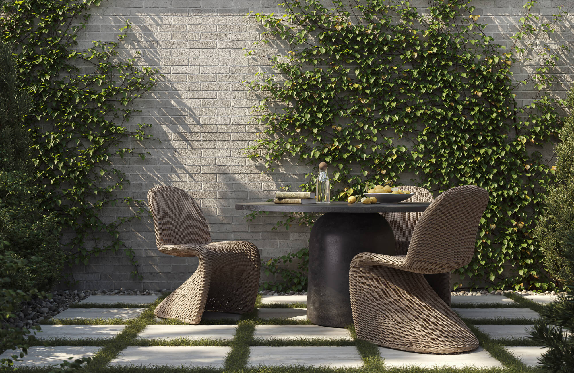 Modern outdoor coffee table with woven chairs on a stone patio, set against a brick wall with climbing greenery in a serene garden setting.