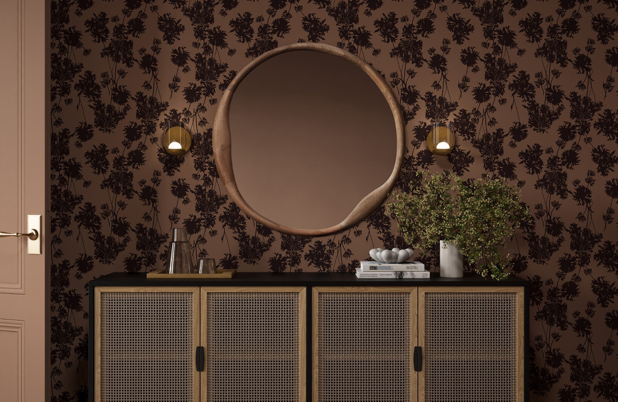 Mid century modern sideboard with cane doors against dark floral wallpaper and round wood mirror.