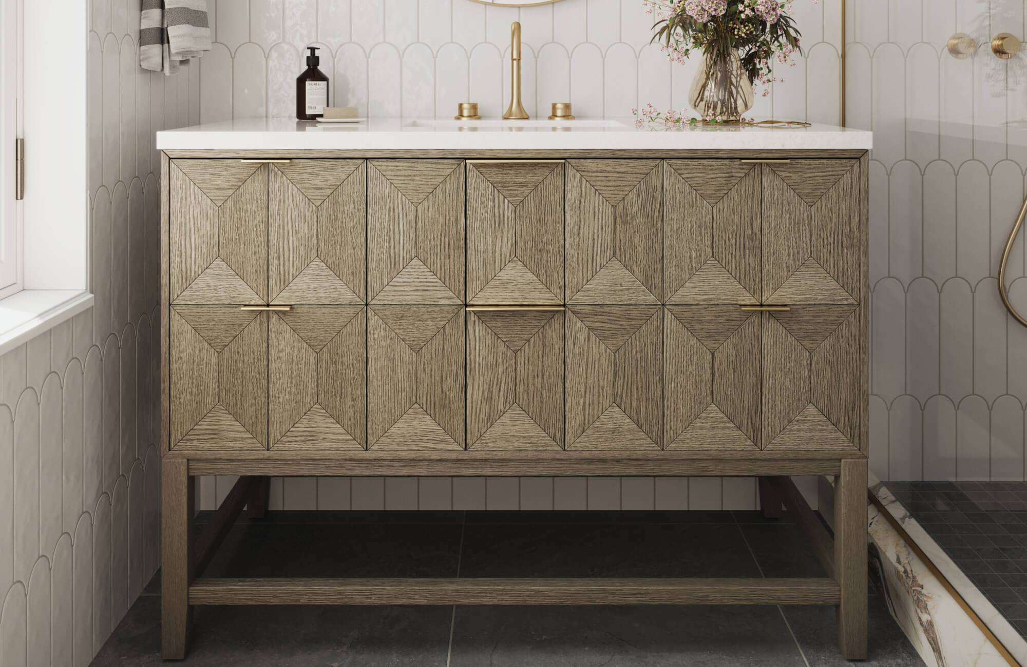 Geometric wood vanity with brass hardware stands out against scalloped wall tiles and dark stone flooring in this stylish bathroom.