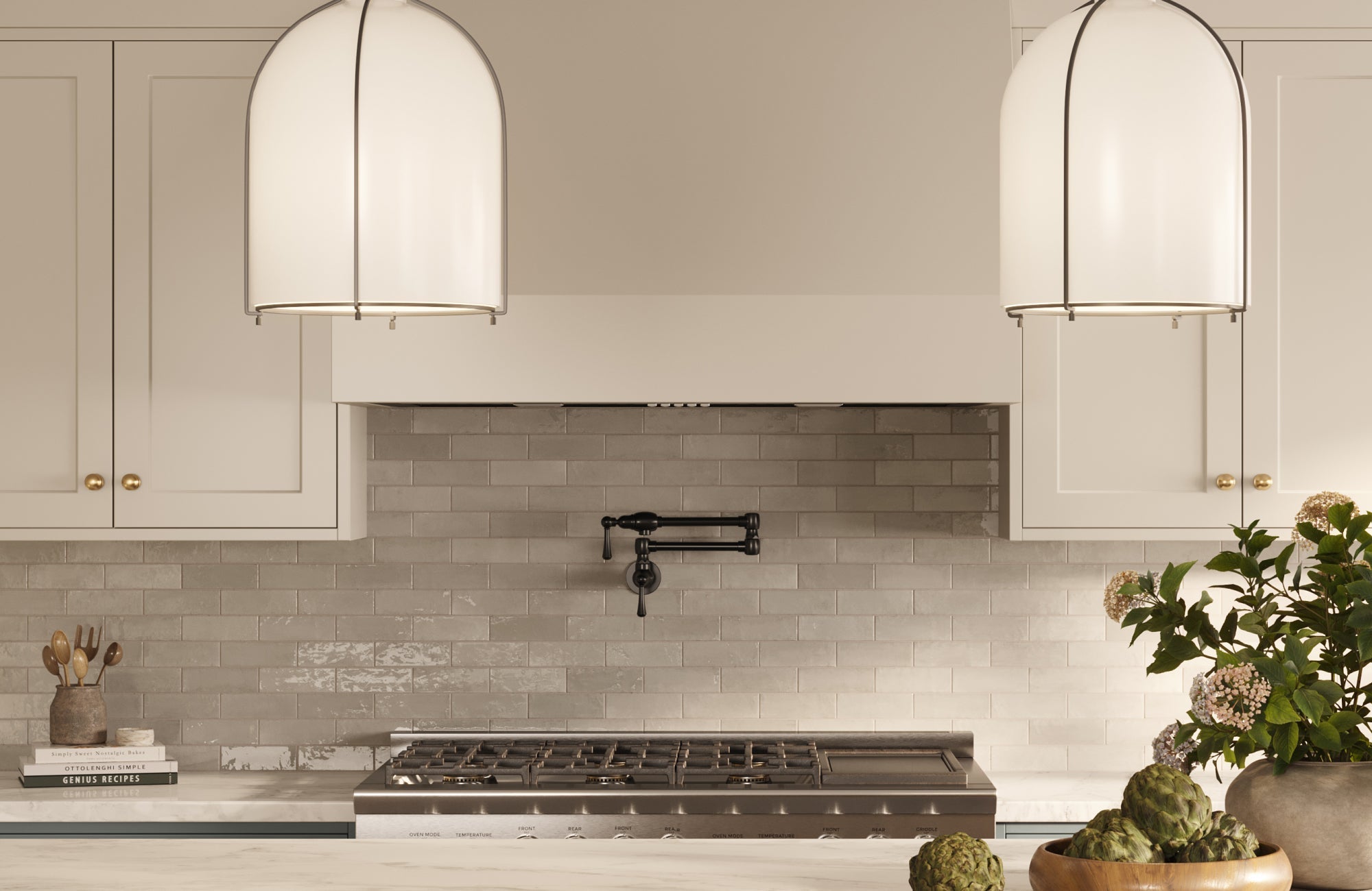 Light gray ceramic subway tile backsplash behind a modern range, paired with white cabinets and large pendant lights.