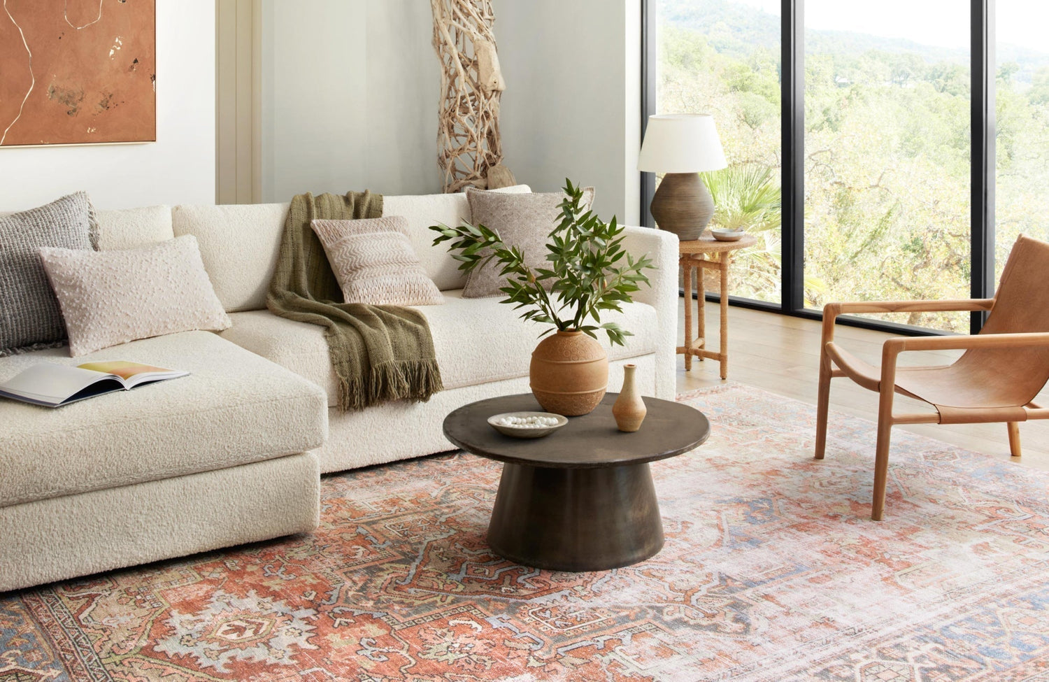 Light-filled living room with sectional sofa and a rug placed lengthwise to match seating orientation.