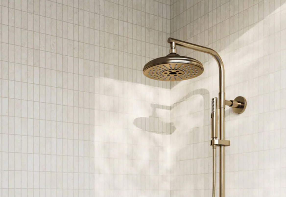 Elegant stone-look tiles in a shower, complemented by a vintage gold showerhead