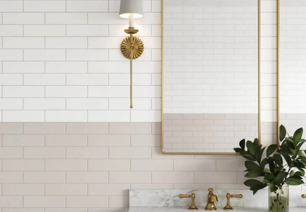 Elegant bathroom featuring soft-hued subway tiles, golden accents, and lush greenery for a timeless yet modern appeal