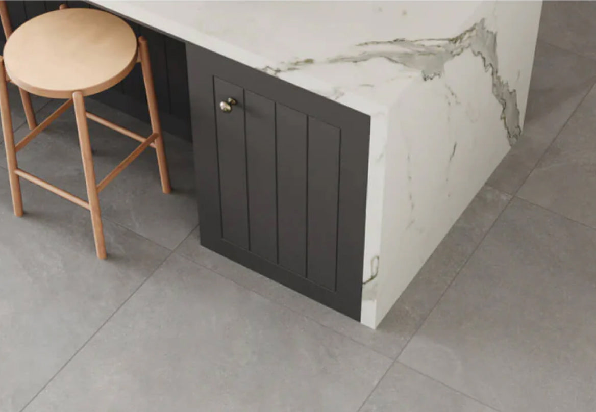 Modern kitchen featuring sleek grey floor tiles paired with dark cabinetry and a white marble countertop, creating a sophisticated and contemporary look