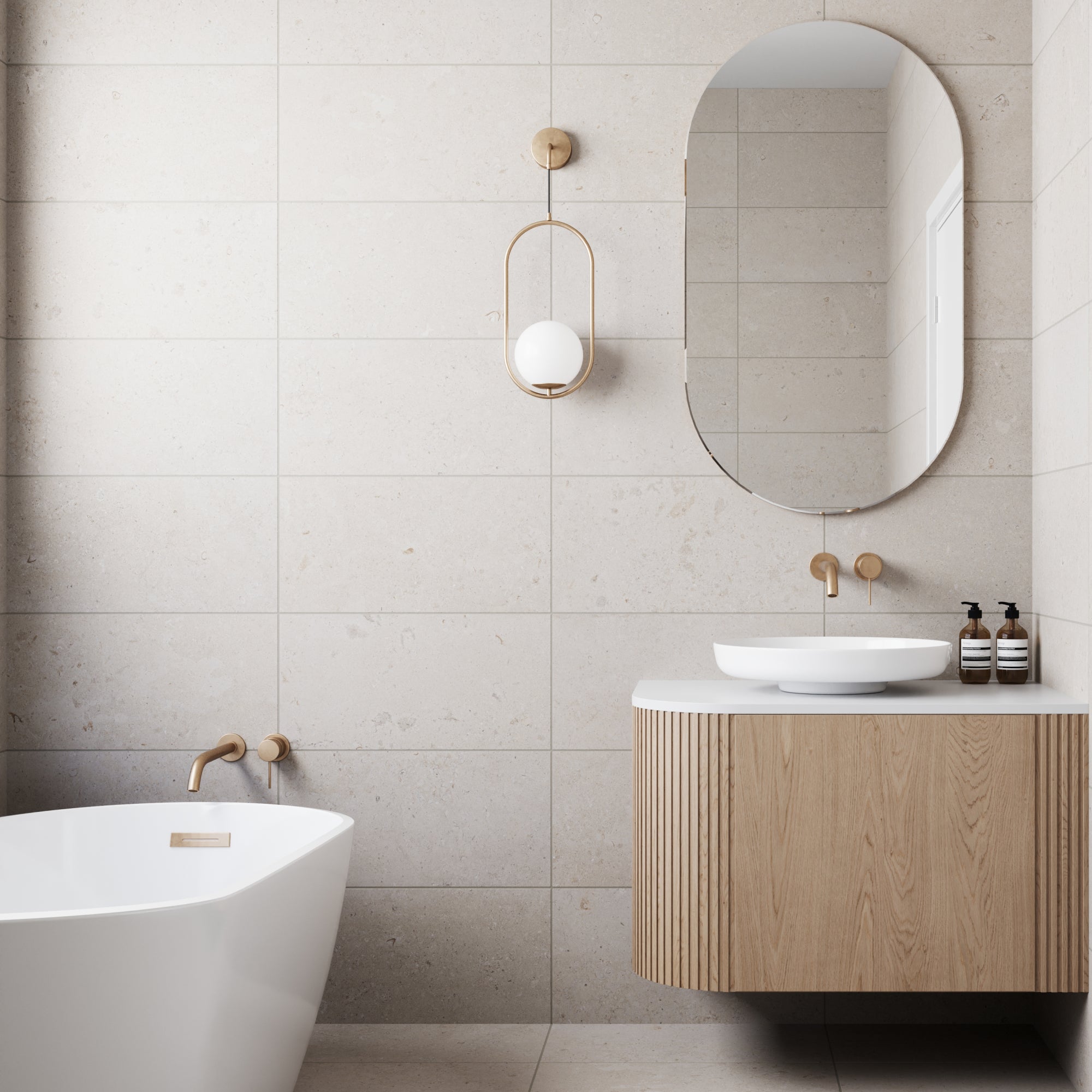 A modern bathroom exuding serene elegance, featuring walls and floors adorned with Wren 12x24 Matte Porcelain Tile in Dune. This limestone-look tile infuses the space with a natural, tranquil ambiance, its subtle textures and warm tones echoing the distinctive beauty of authentic limestone. Every detail contributes to a sanctuary where contemporary design meets timeless, organic allure.