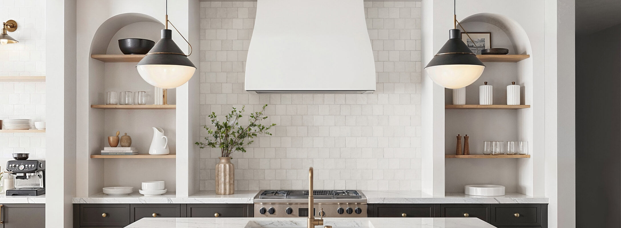 A modern kitchen featuring a sleek white backsplash made of square tiles, creating a clean, timeless look that complements the natural wood shelves and brass accents