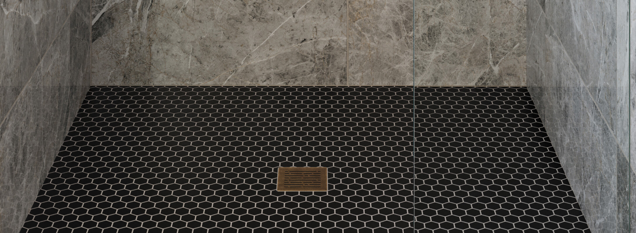Modern shower floor with black hexagonal mosaic tiles, complemented by sleek grey marble look walls, creating a stylish and contemporary look
