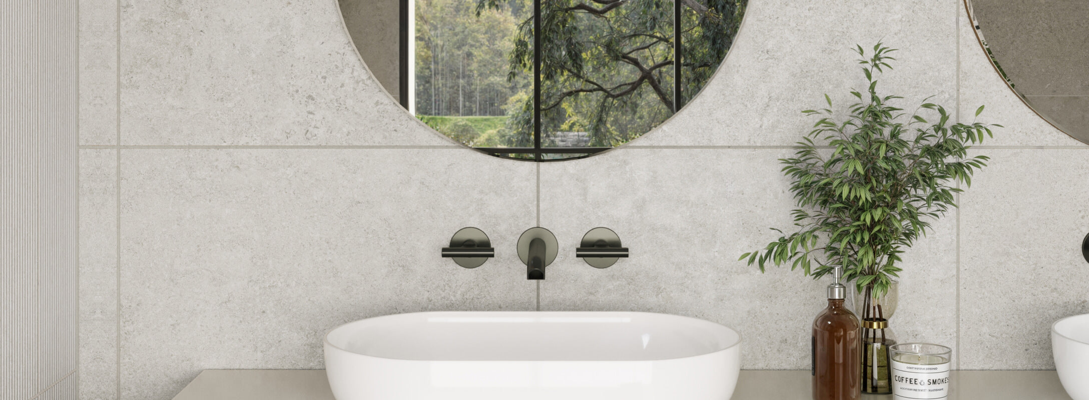 Modern bathroom with light grey textured tiles and a contemporary oval sink, complemented by a round mirror and greenery