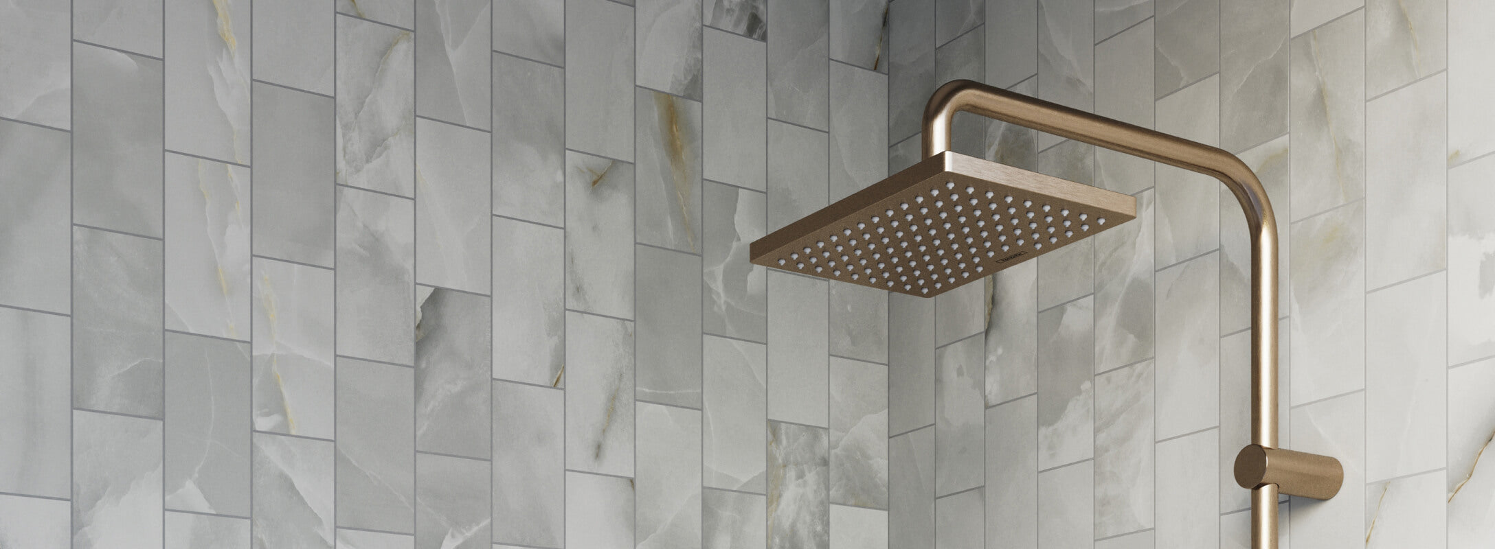 Stylish shower with light grey marble look mosaic tiles and a large square brass showerhead, creating a luxurious and modern look