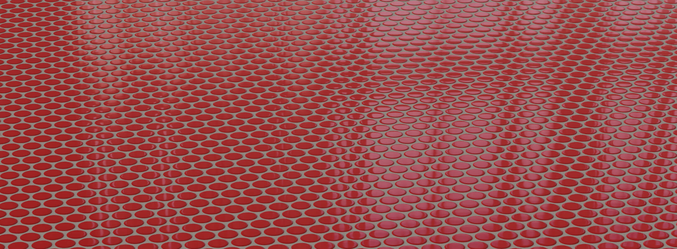 Vibrant red mosaic tiles with a glossy finish, arranged in a circular pattern, creating a bold and dynamic look for shower floors