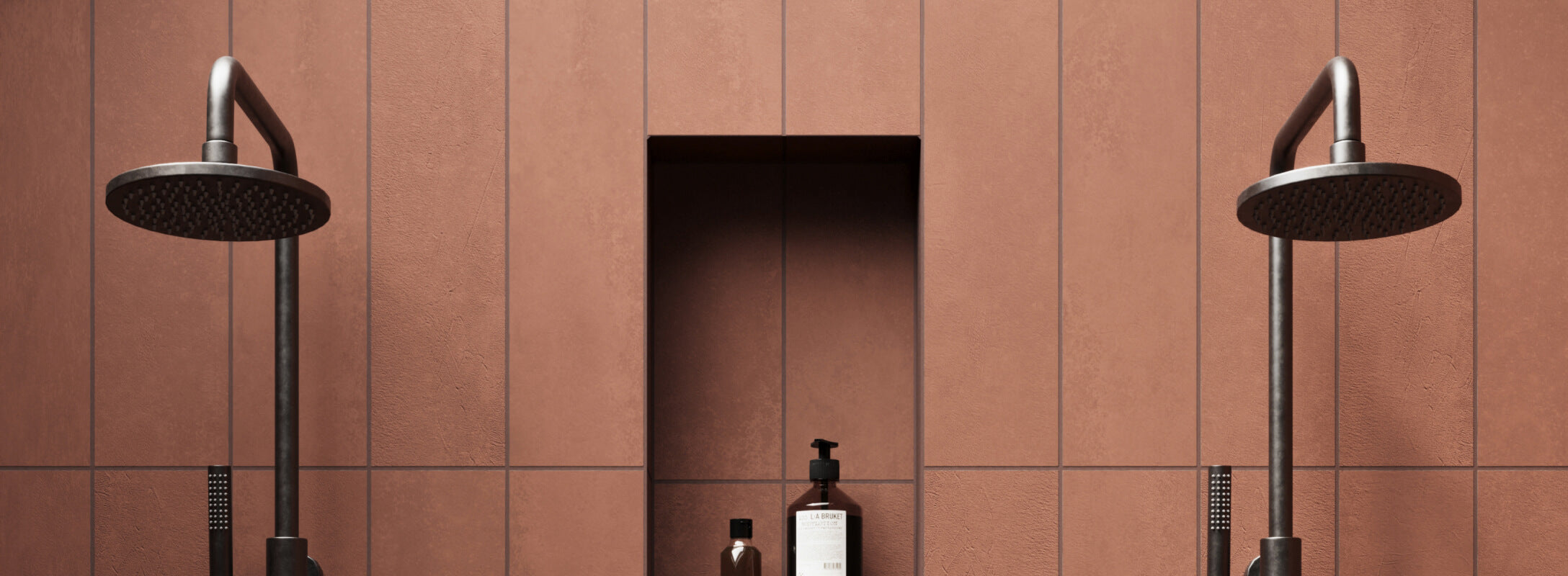 Close-up of modern shower with matte red tiles and dual rainfall showerheads, highlighting built-in shelf for toiletries, creating a chic and bold look