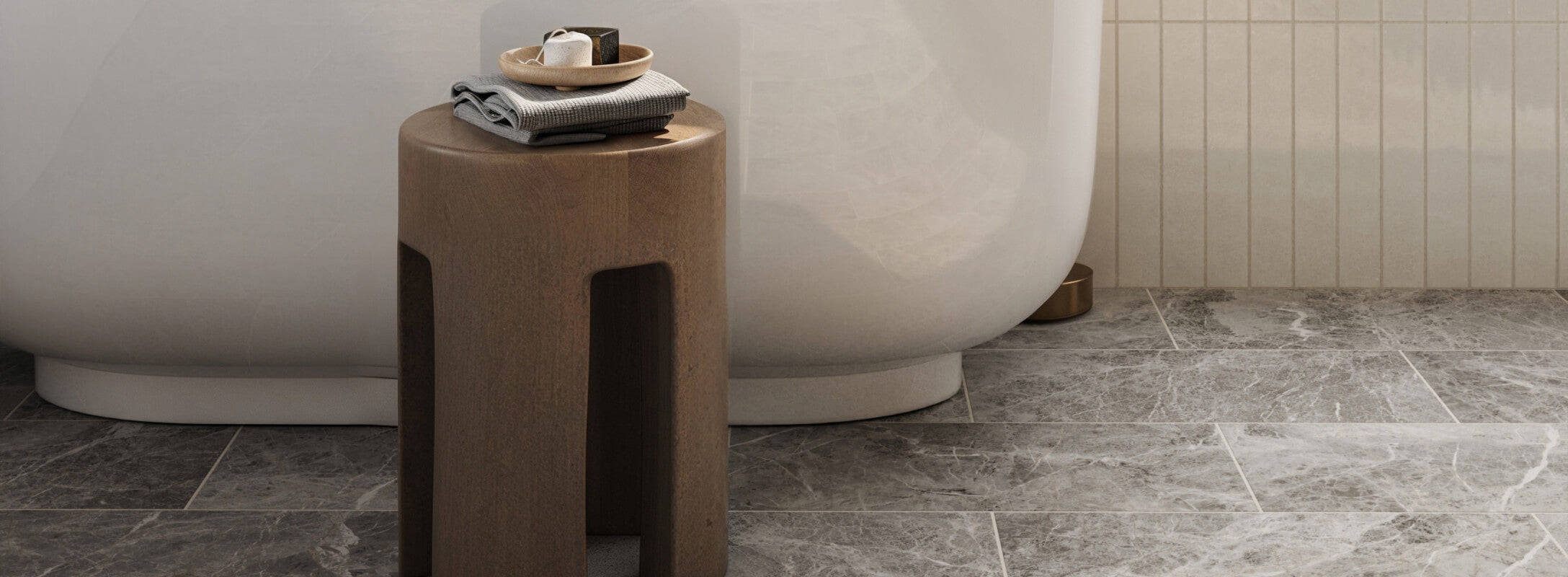 Matte marble look grey floor tiles in a sleek bathroom featuring a modern wooden stool and a luxurious bathtub