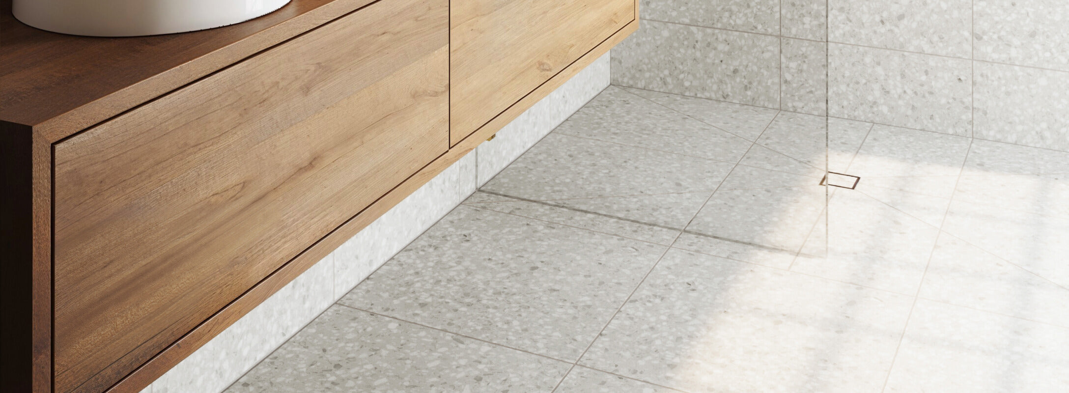 Light grey terrazzo look floor tiles in a contemporary bathroom with a wooden vanity unit and sleek design