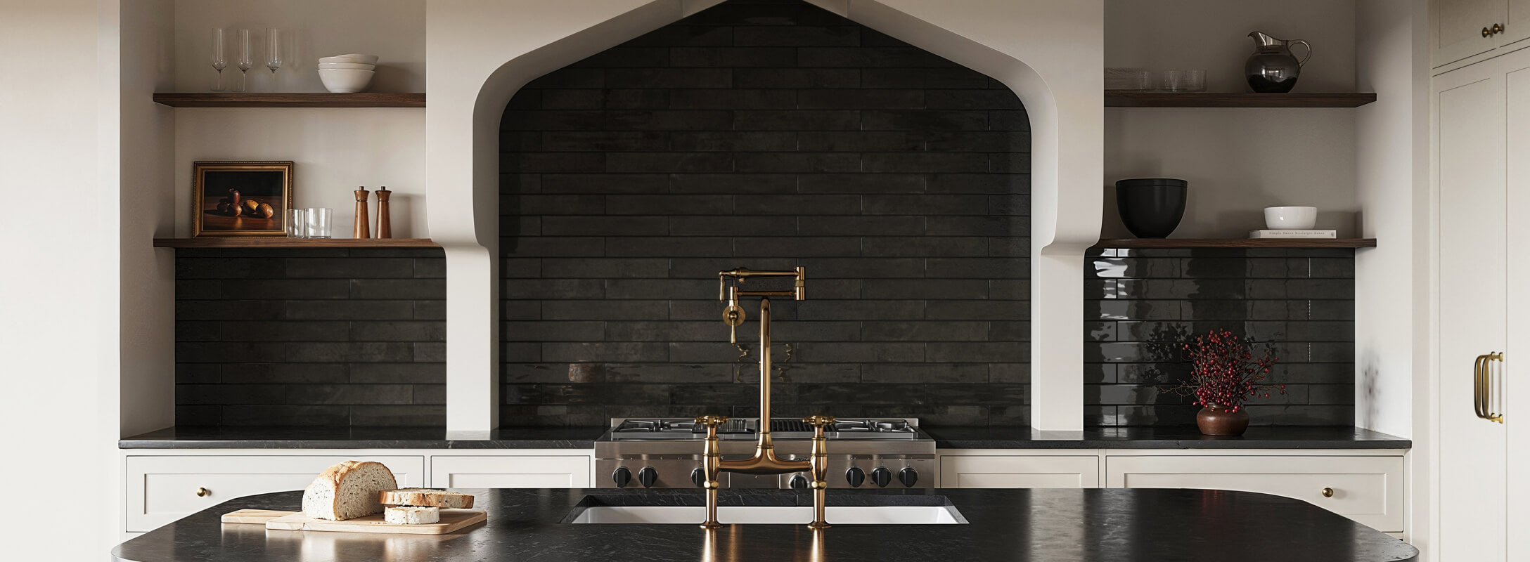 Modern kitchen featuring glossy black tiles as a backsplash, paired with brass fixtures and minimalist open shelving for a sleek, sophisticated look