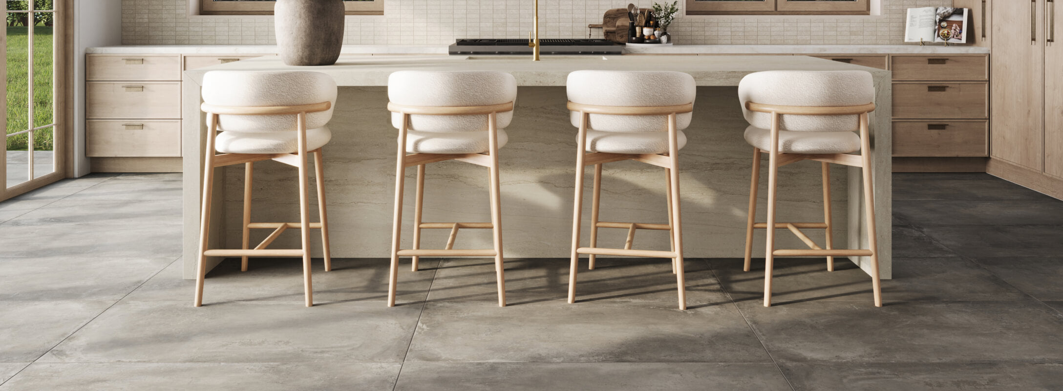 Elegant dark grey kitchen floor tiles paired with a light wood island and white upholstered bar stools, creating a chic and modern kitchen atmosphere