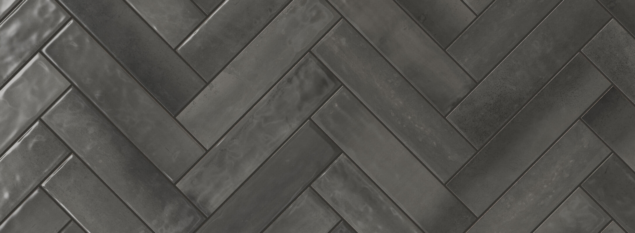 Dark grey herringbone tiles with a sleek, glossy finish create a sophisticated and modern look, perfect for contemporary kitchen walls