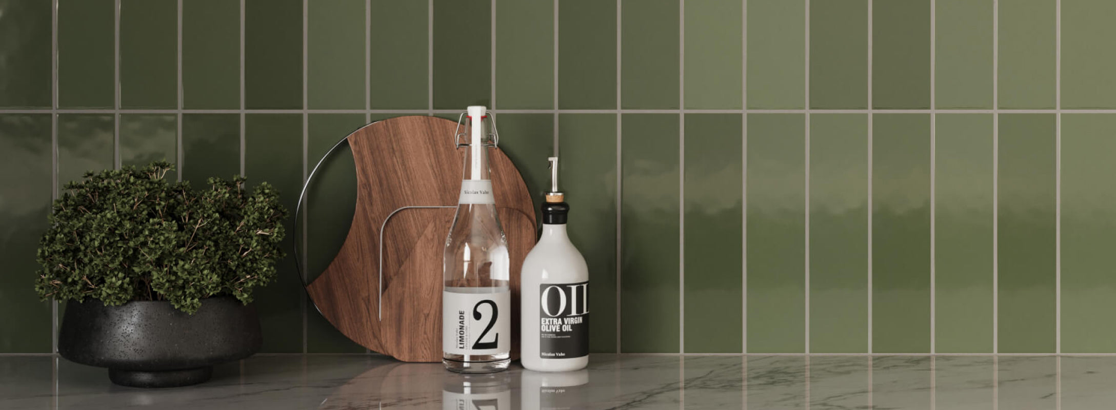 Glossy green subway tiles in a sleek kitchen, contrasted with a white marble countertop and decorative items