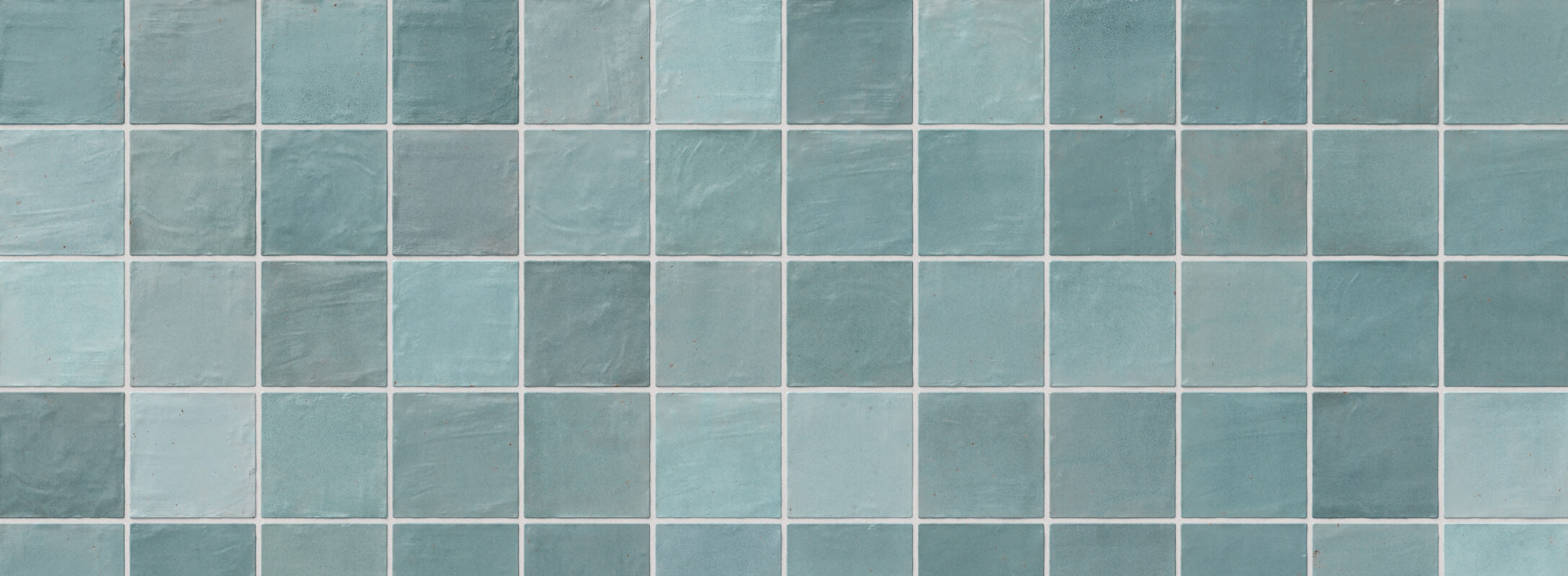 Muted multicolor tiles in varying shades of blue and teal, creating a calming and serene aesthetic perfect for kitchen walls