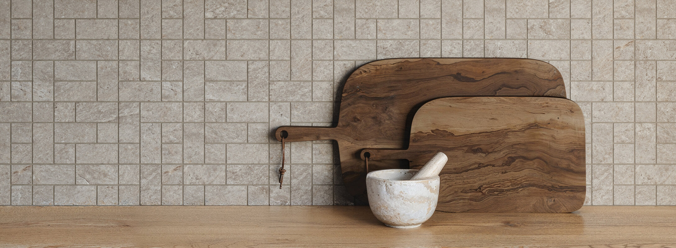Textured taupe kitchen tiles providing a natural stone look, paired with wooden cutting boards and a mortar and pestle