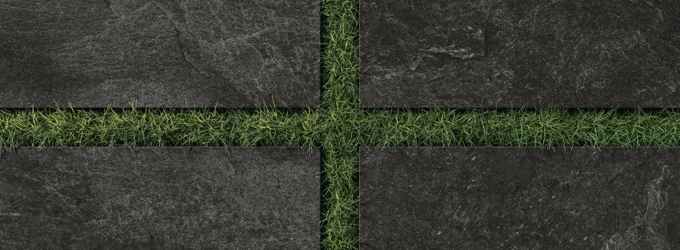 Natural black paver tiles with subtle stone textures paired with vibrant green grass create a striking outdoor grid design.