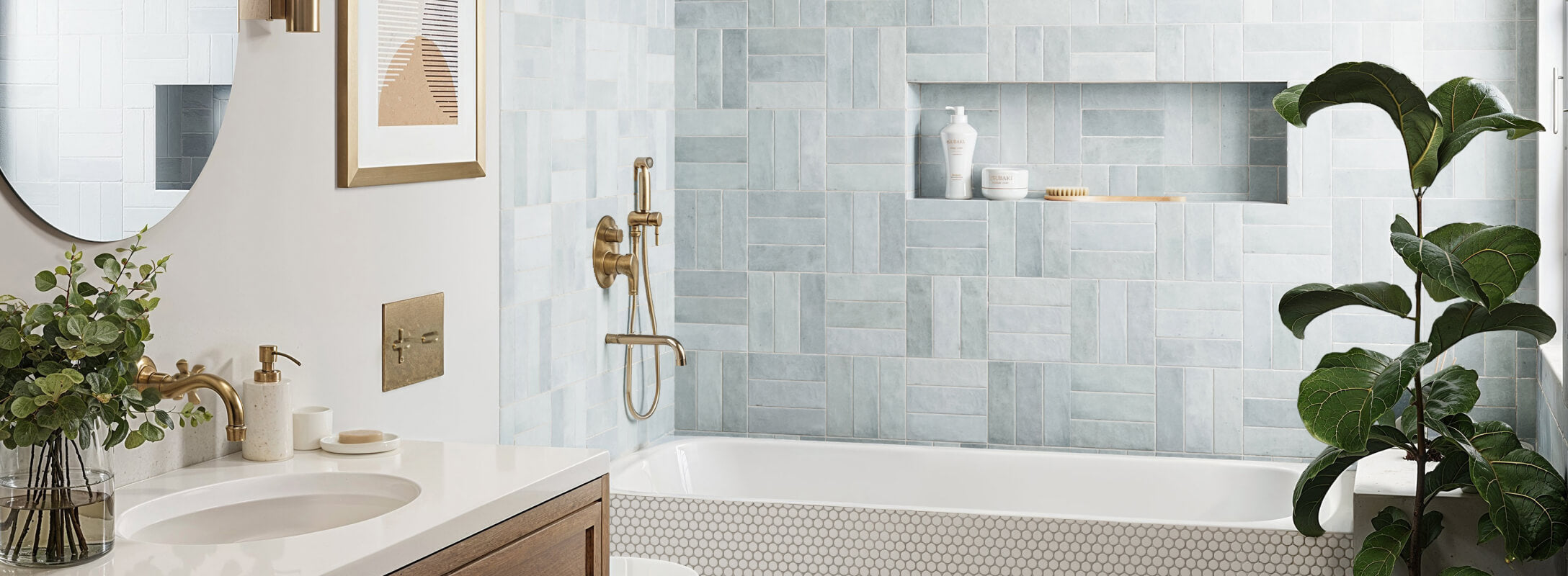 Stylish bathroom featuring blue subway tiles arranged in a modern pattern, complemented by brass fixtures and a built-in niche for storage