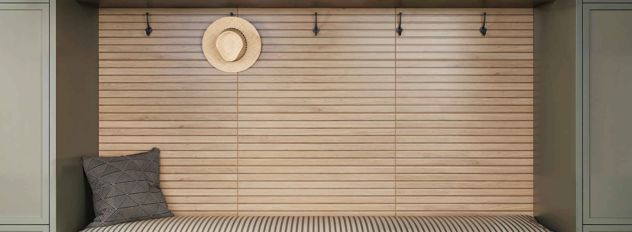 Cozy nook with horizontal wooden slat wall tiles, soft green cabinetry, and a striped cushion, completed with a hanging straw hat for a rustic touch