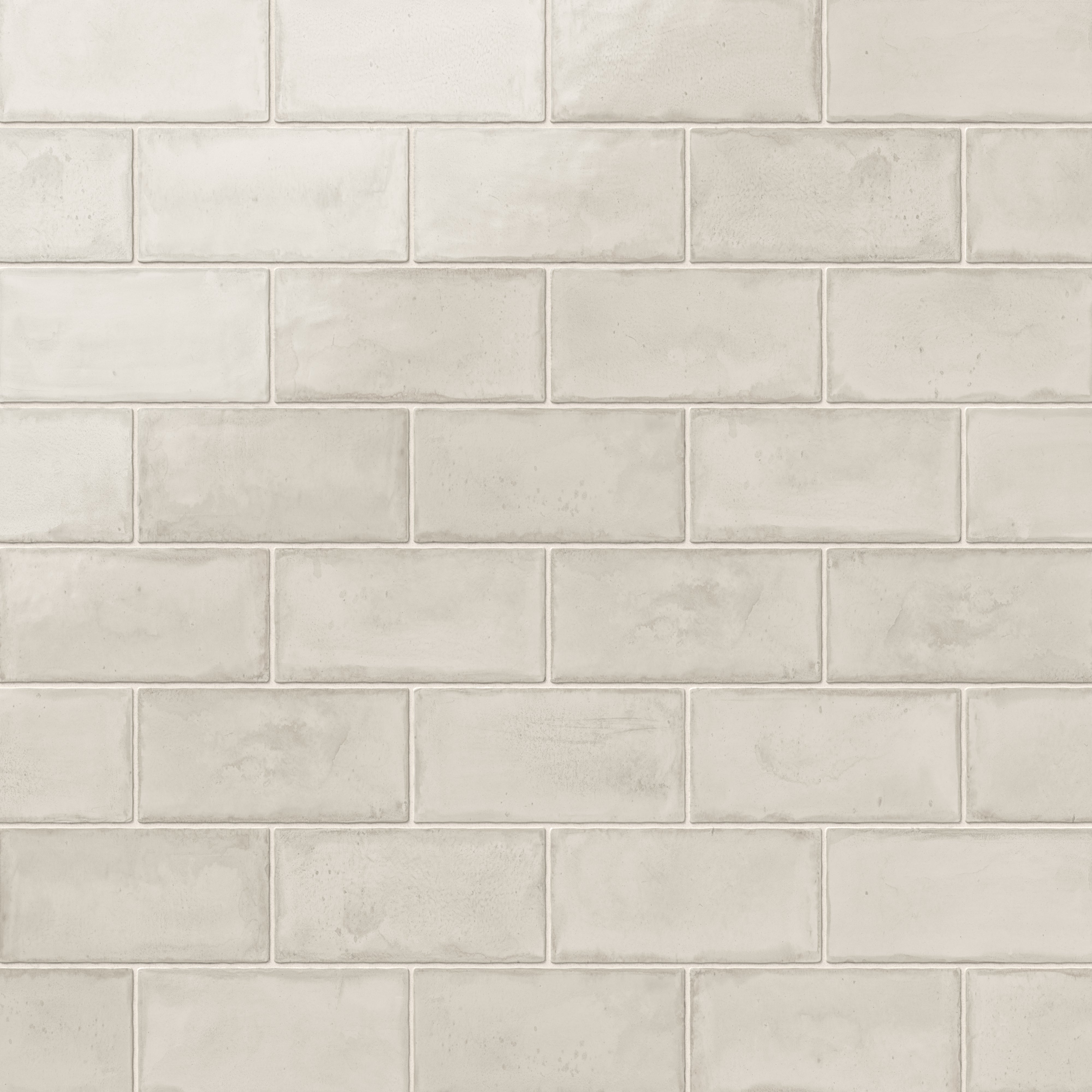 Glossy beige-colored ceramic subway tiles in a 3x6 format, featuring a soft, handmade texture for a timeless and elegant design