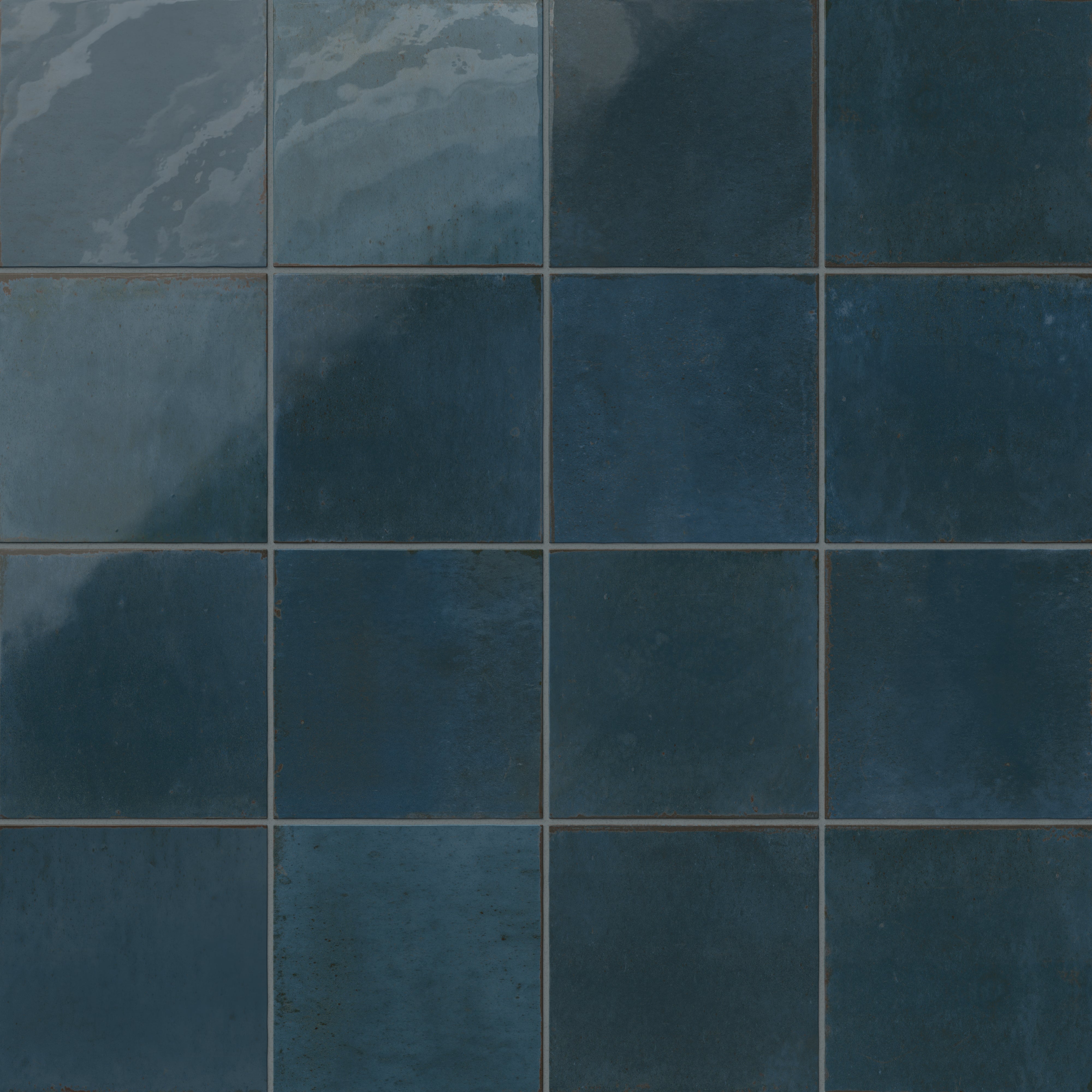 Deep blue porcelain tiles with handcrafted texture and tonal shifts for a weathered look.