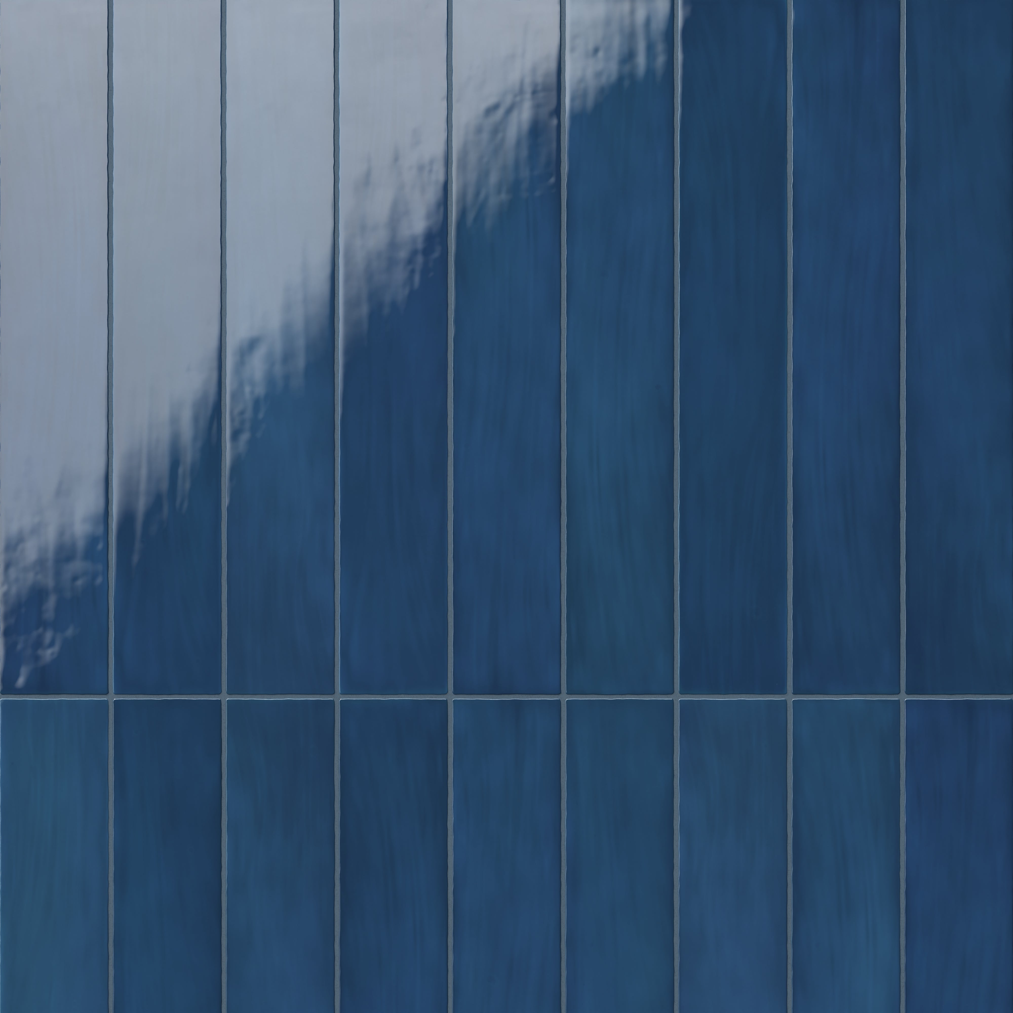 Close-up of cobalt blue ceramic subway tiles with a rich, glossy finish, showcasing subtle tonal variations
