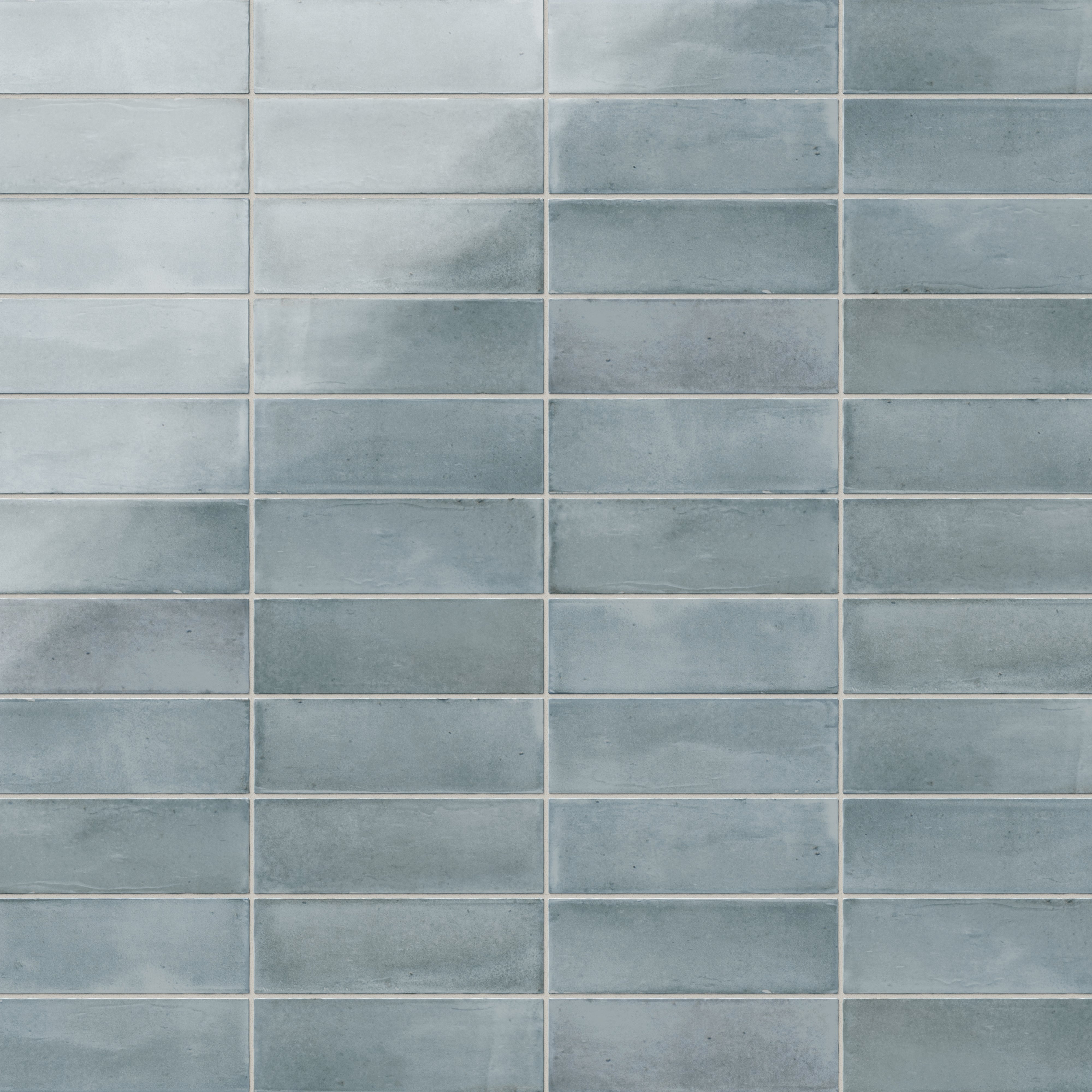 A 2x6 porcelain subway tiles in light blue, featuring a glossy finish, and a clean stacked layout with fine grout lines.