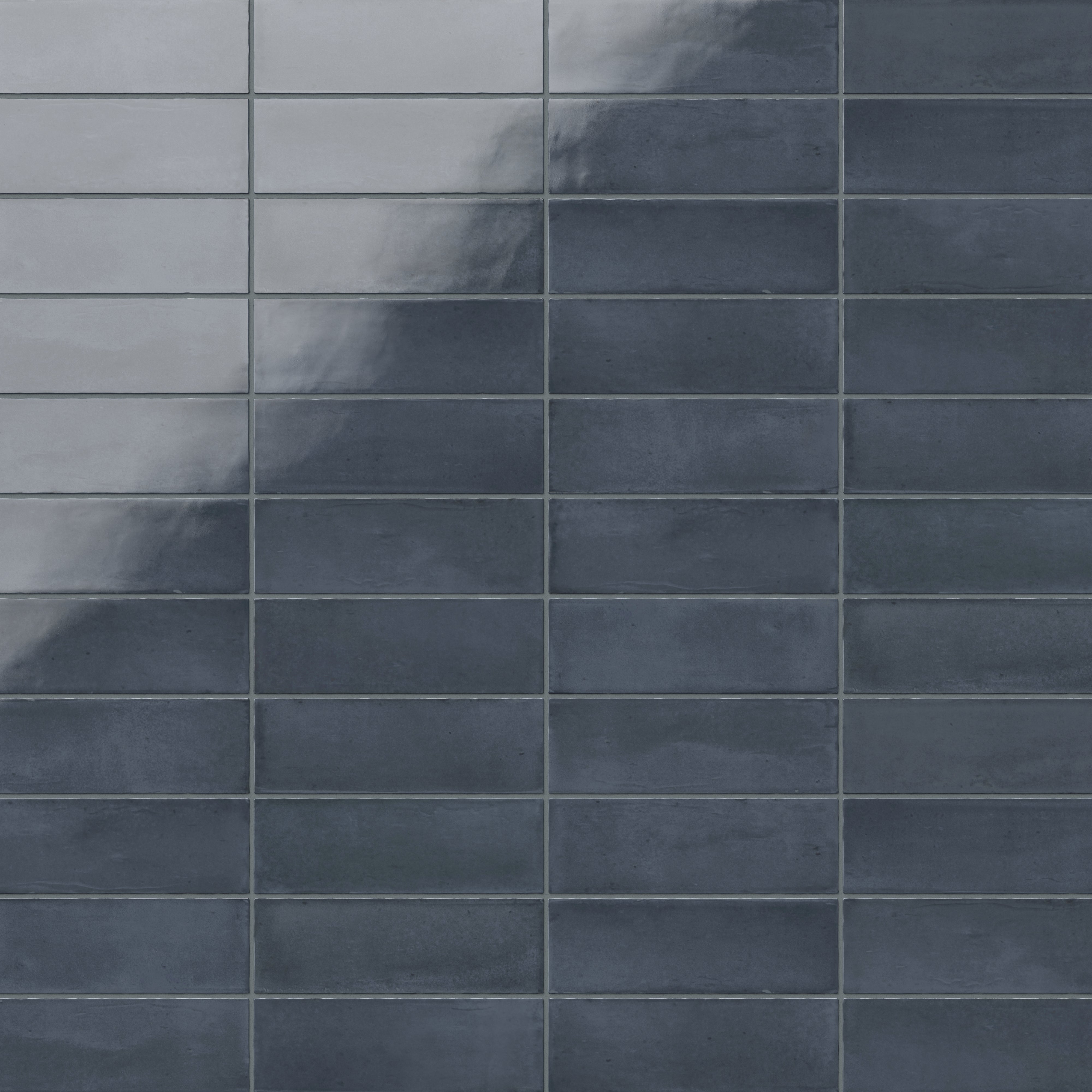 A 2x6 porcelain subway tile in blue, featuring a glossy finish, and a clean stacked layout with fine grout lines.