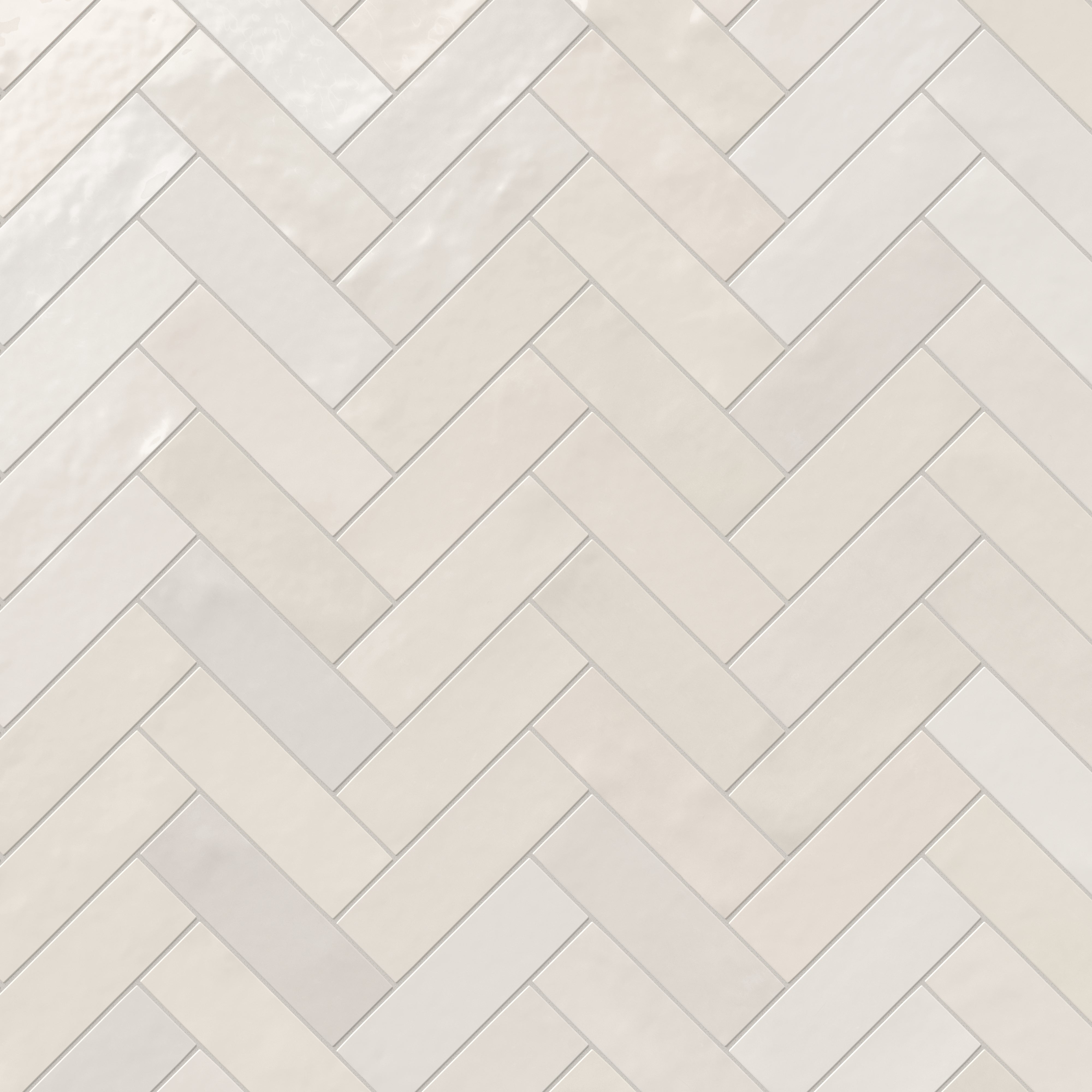 Jojo subway tile in Ivory arranged in a classic herringbone pattern, showcasing its glossy finish and elegant geometry