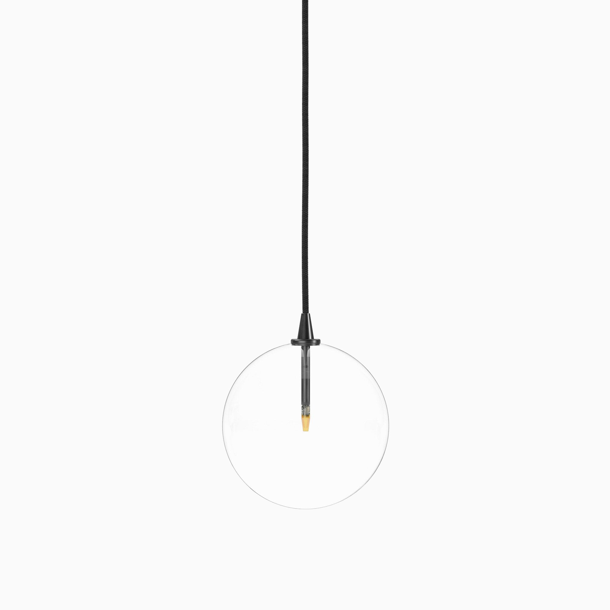 Minimalist pendant light with a clear glass globe, suspended by a black gunmetal cord and featuring a slim black and brass vertical socket.
