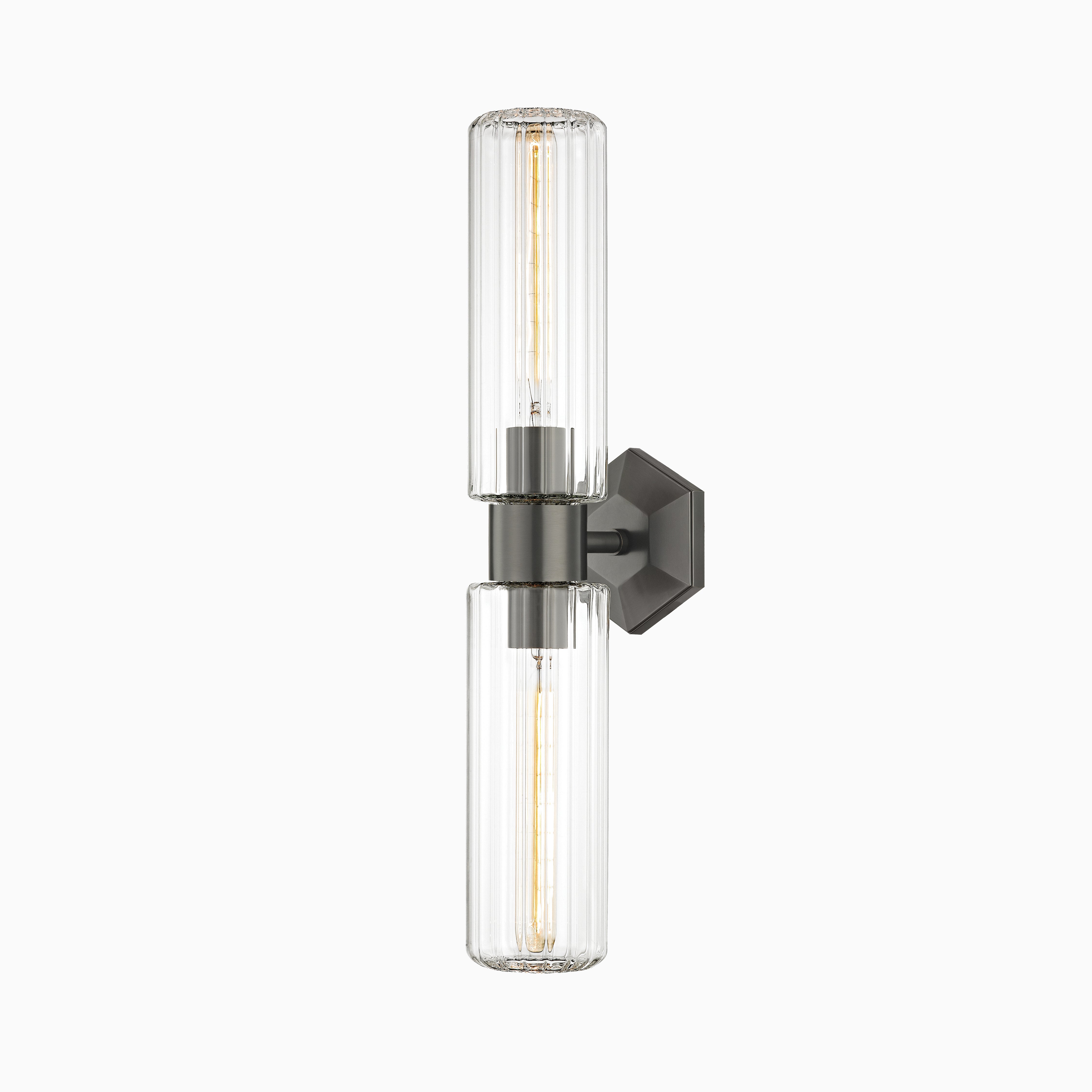 Wall sconce with matte old bronze base, hexagonal backplate, and twin cylindrical fluted glass shades for ambient lighting.