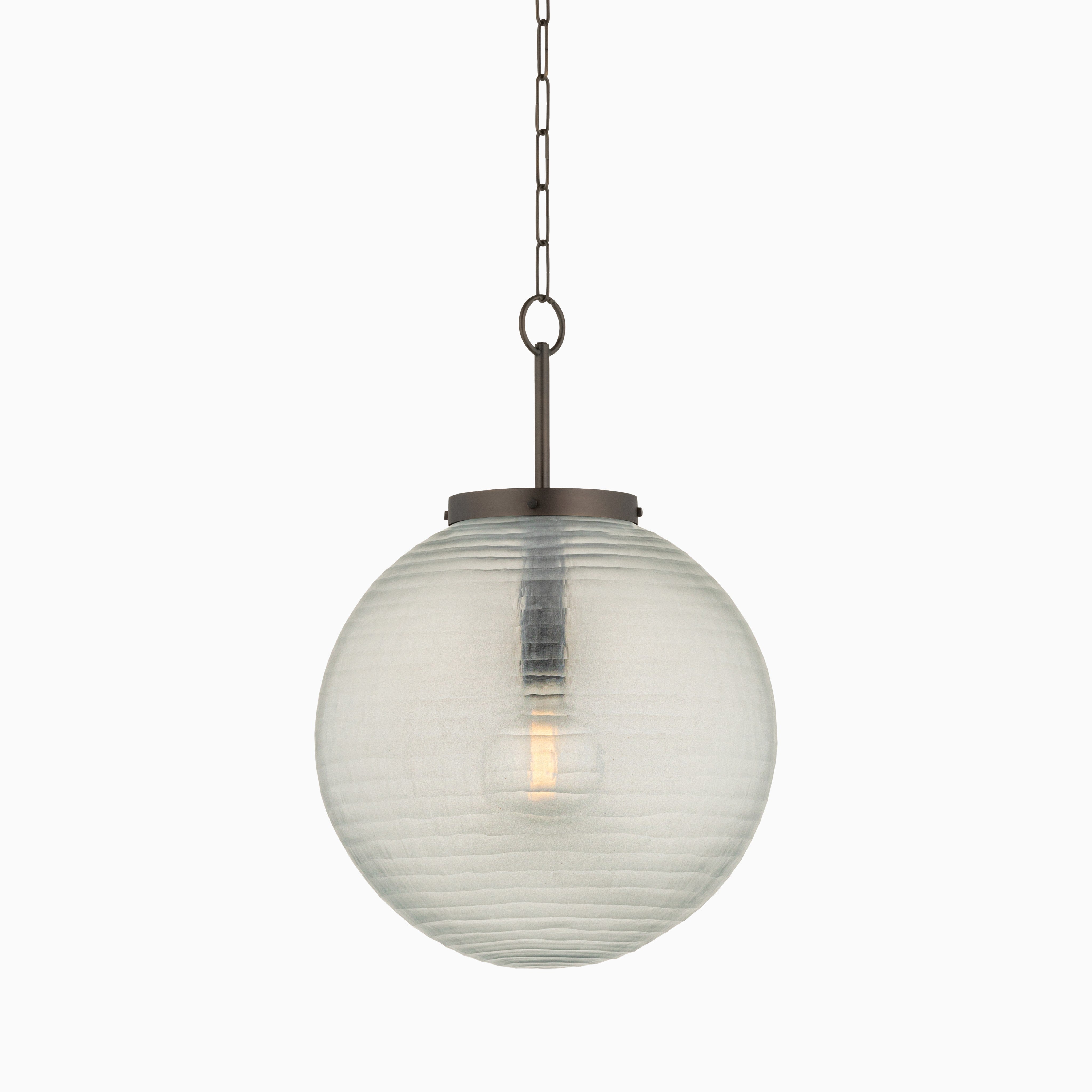 Textured glass globe pendant light with a distressed bronze chain and canopy, showcasing a visible bulb within the spherical shade.