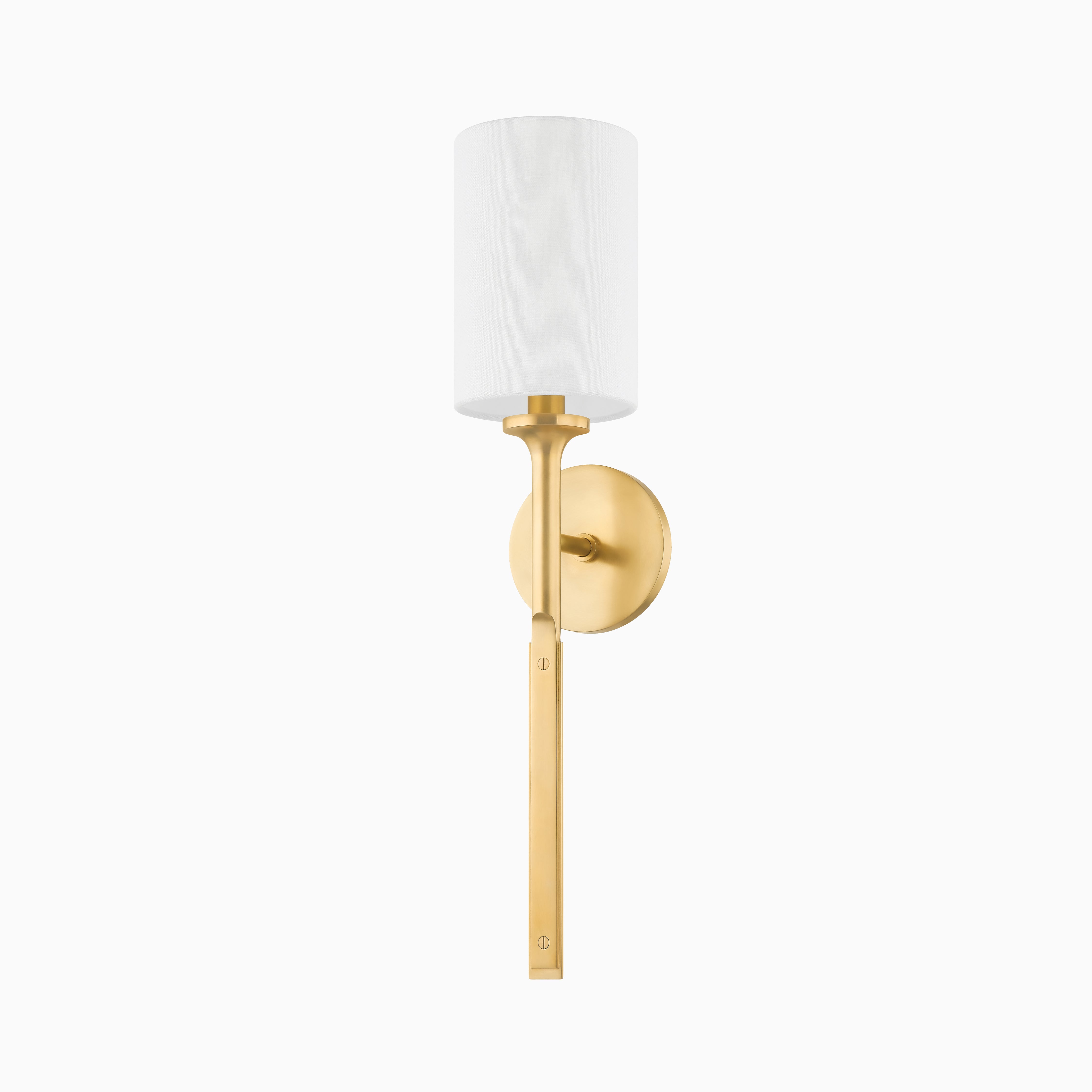 Geraldine wall sconce in aged brass with a crisp white cylindrical shade and tailored arm, offering timeless style and soft illumination.