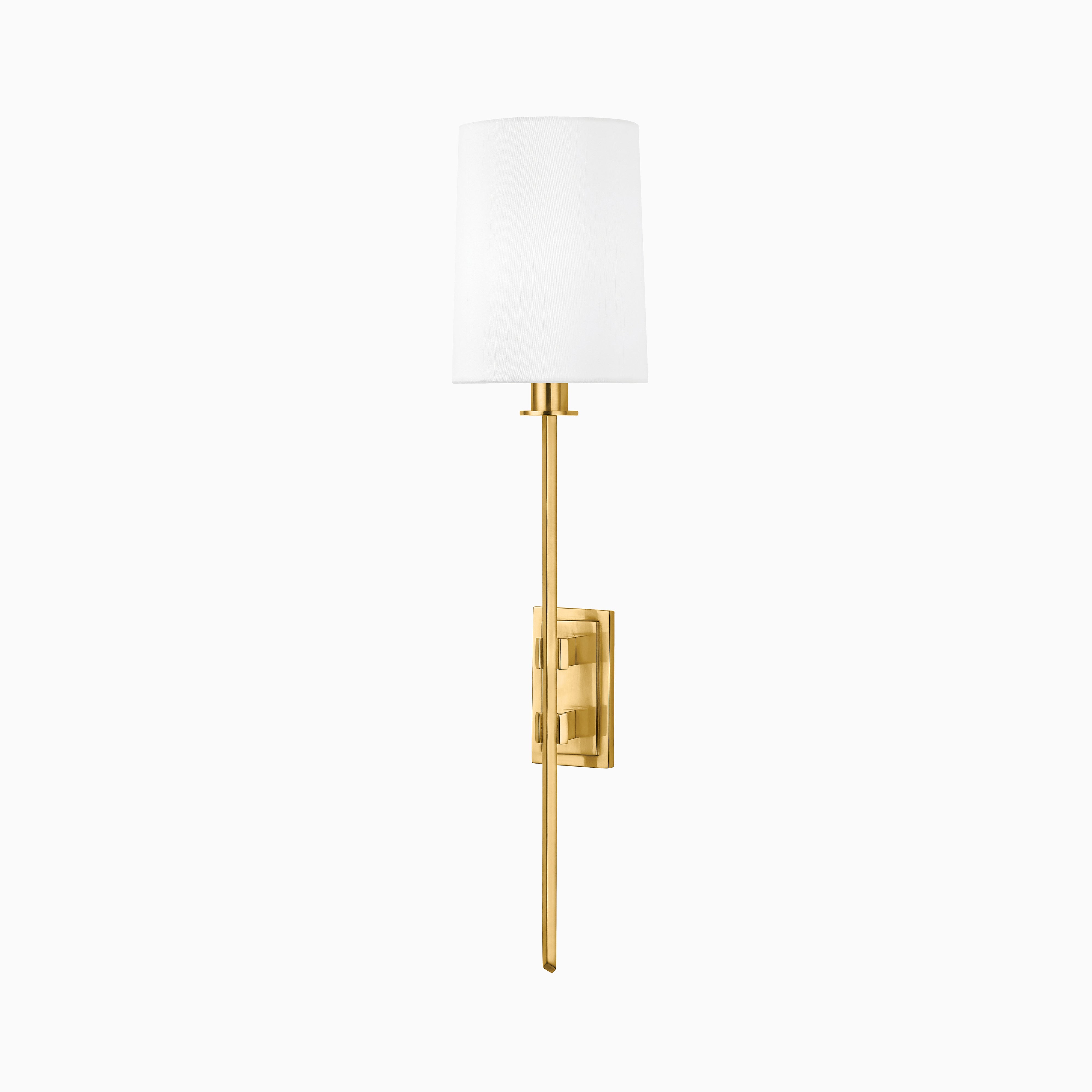 Our Johansson Wall Sconce in Aged Brass with a slim rod, rectangular backplate, and tapered faux silk shade—ideal for adding ambient light to hallways, bathrooms, or bedrooms.