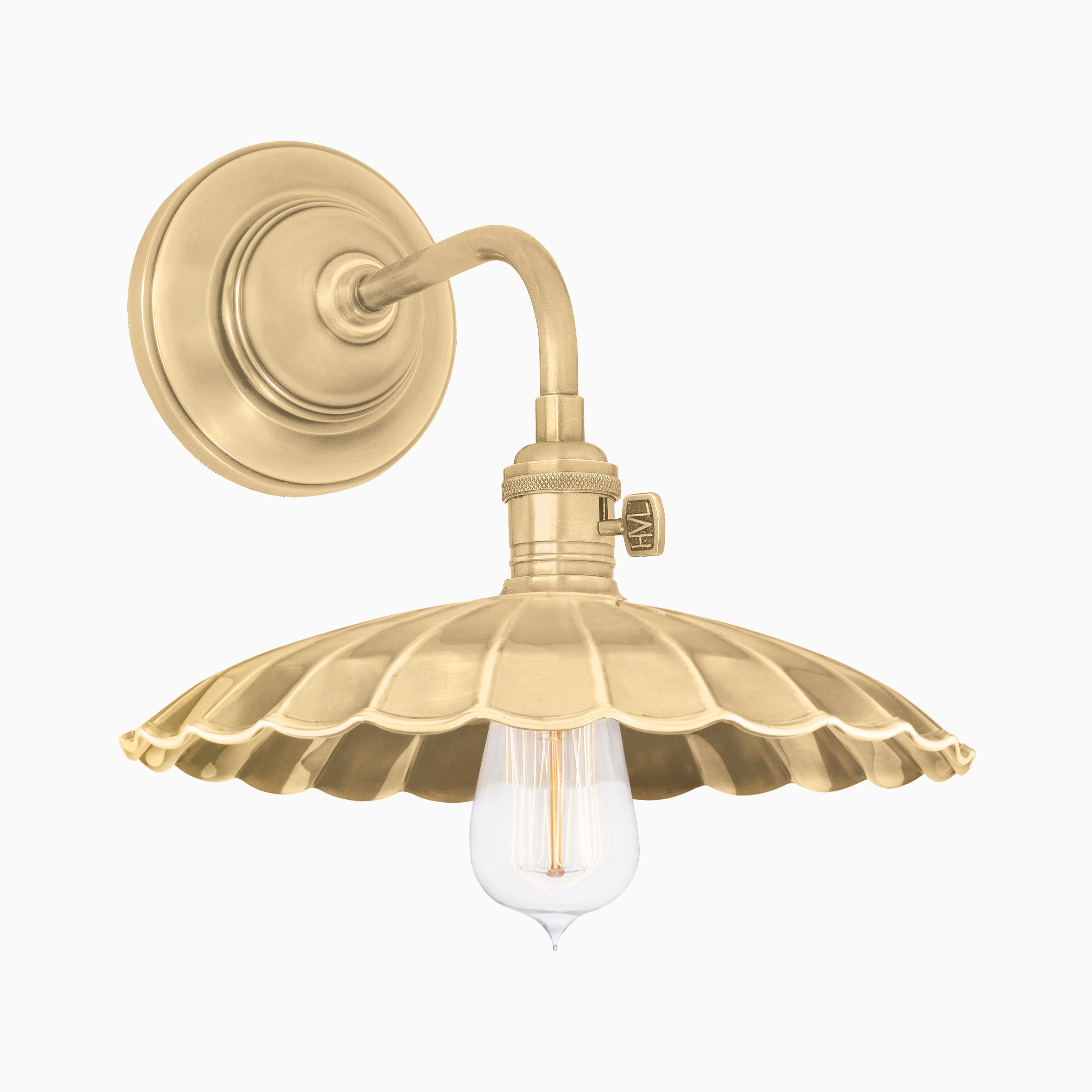 Vintage-inspired brass wall sconce with a scalloped shade and exposed bulb, blending charm with industrial flair