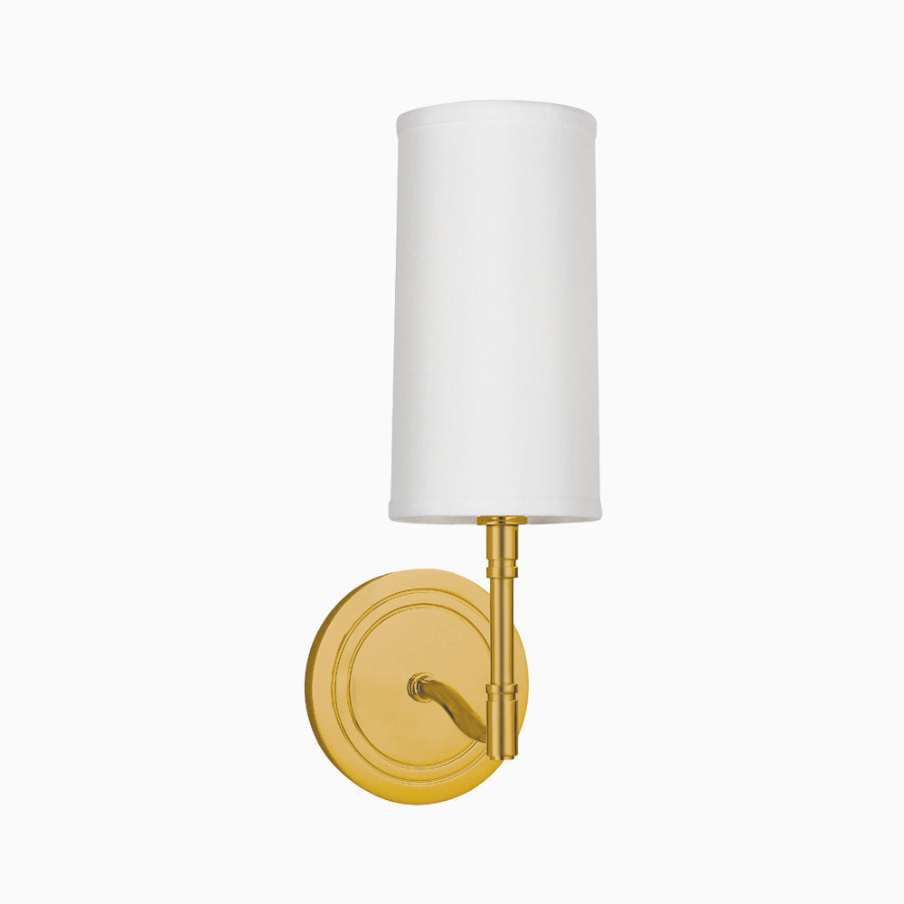 Perkins wall sconce in aged brass with a slender cylindrical white shade and round backplate, exuding timeless elegance.